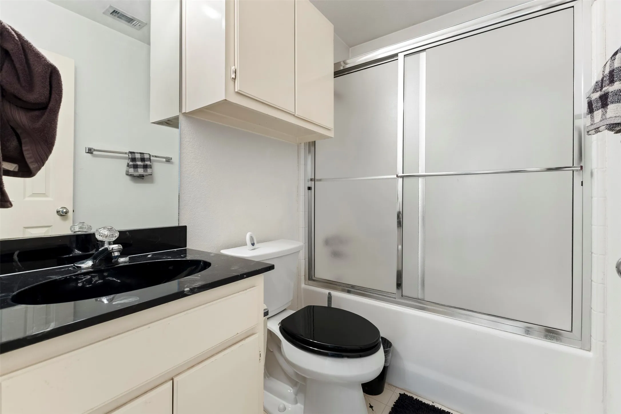 Bathroom vanity with a black countertop and integrated sink