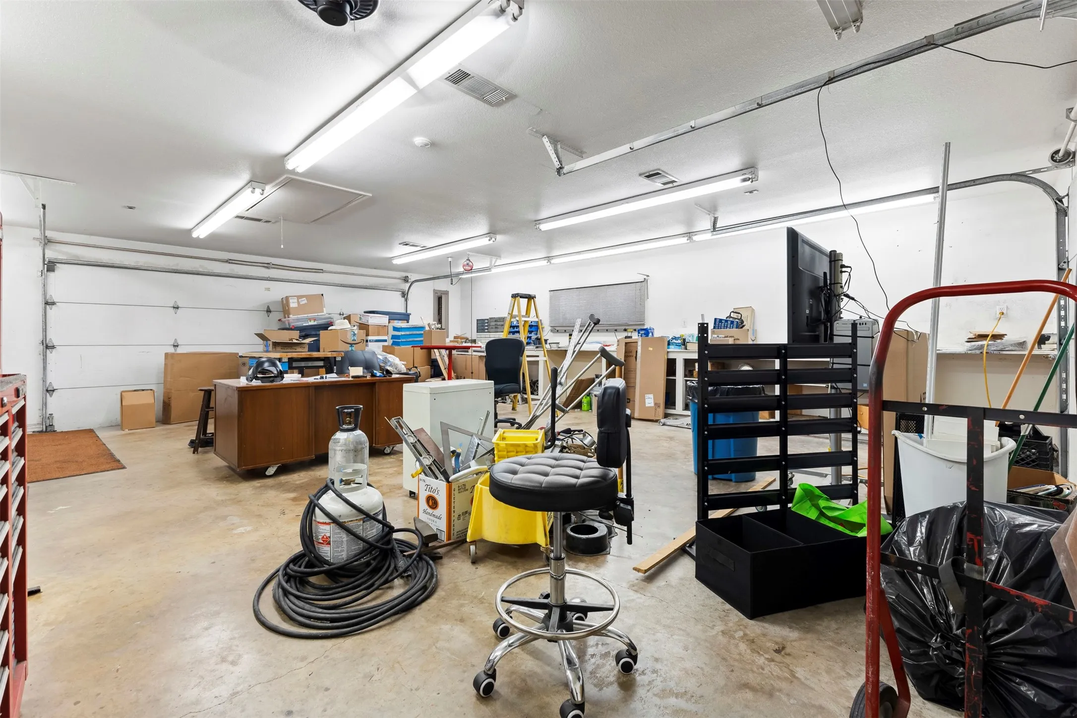 HVAC, Spacious garage featuring concrete flooring and two overhead garage doors
