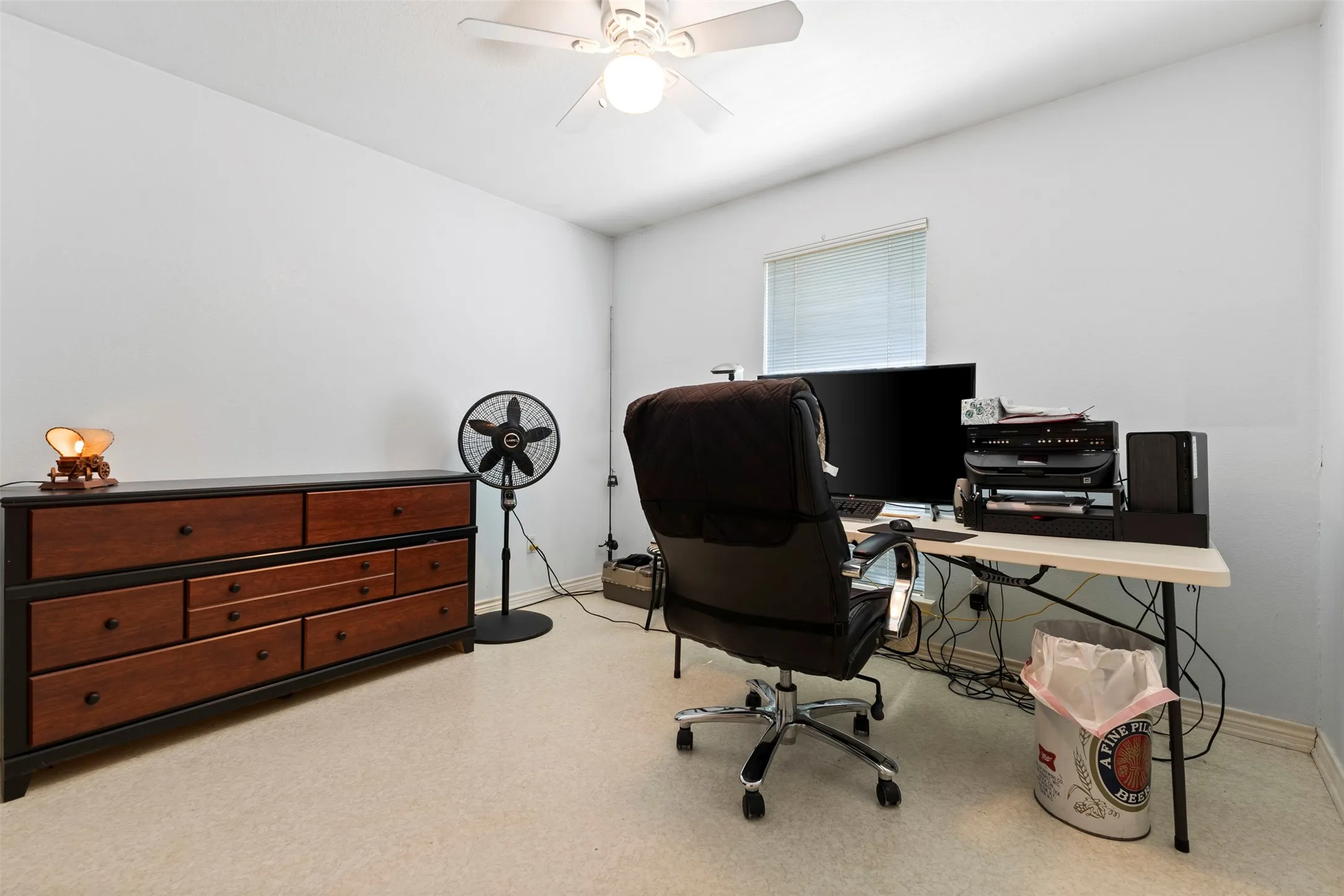 Light-colored walls defining a room with light-colored flooring, featuring a ceiling fan with integrated lighting