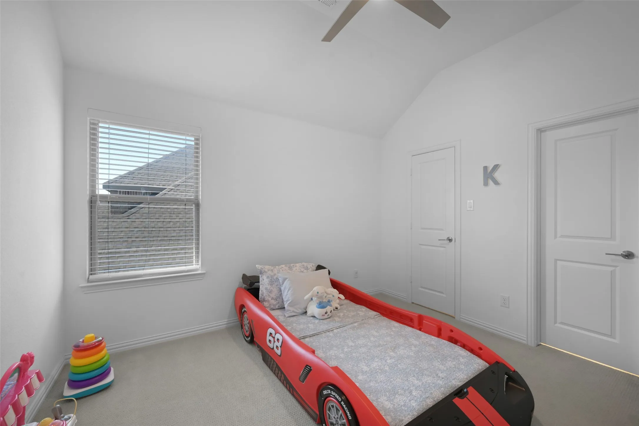 Interior room featuring a vaulted ceiling and light-colored carpet flooring