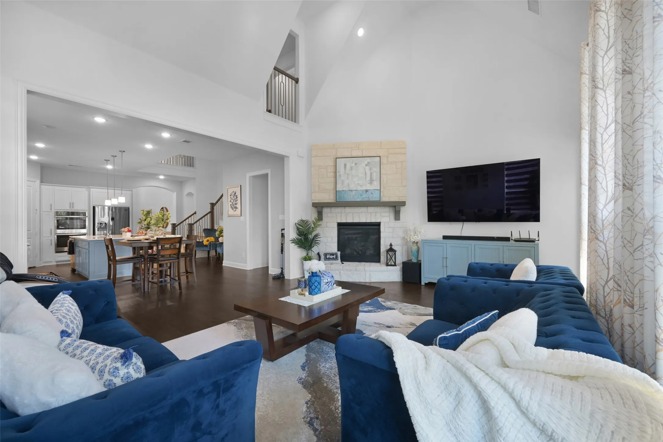 Spacious living area featuring a vaulted ceiling and dark wood-finish flooring