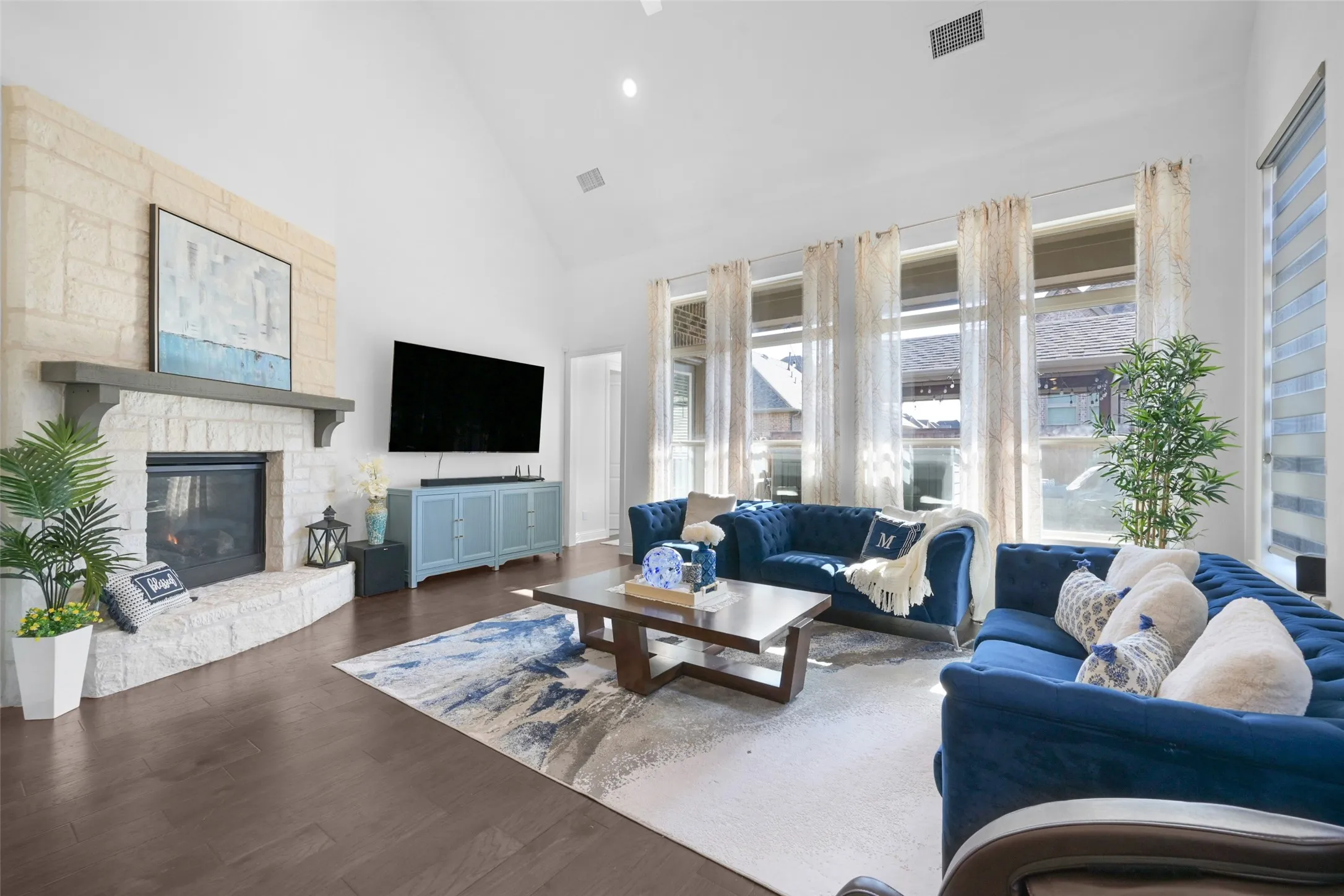 Spacious living area featuring a vaulted ceiling and dark wood-finish flooring