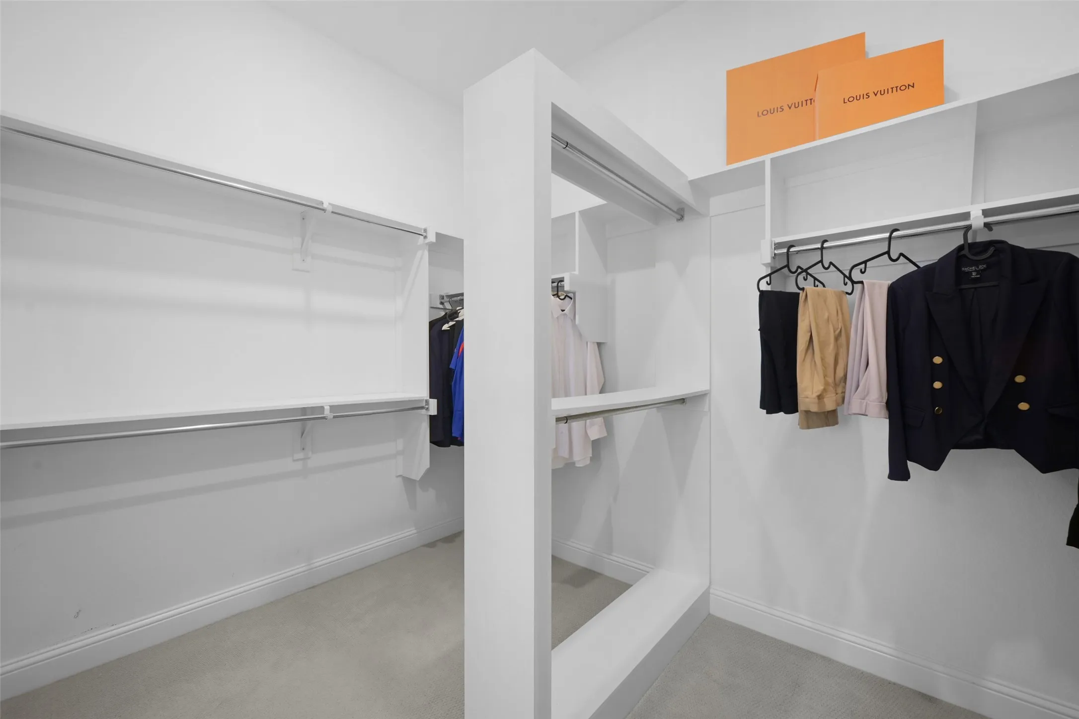 Custom closet system featuring white shelving and chrome hanging rods