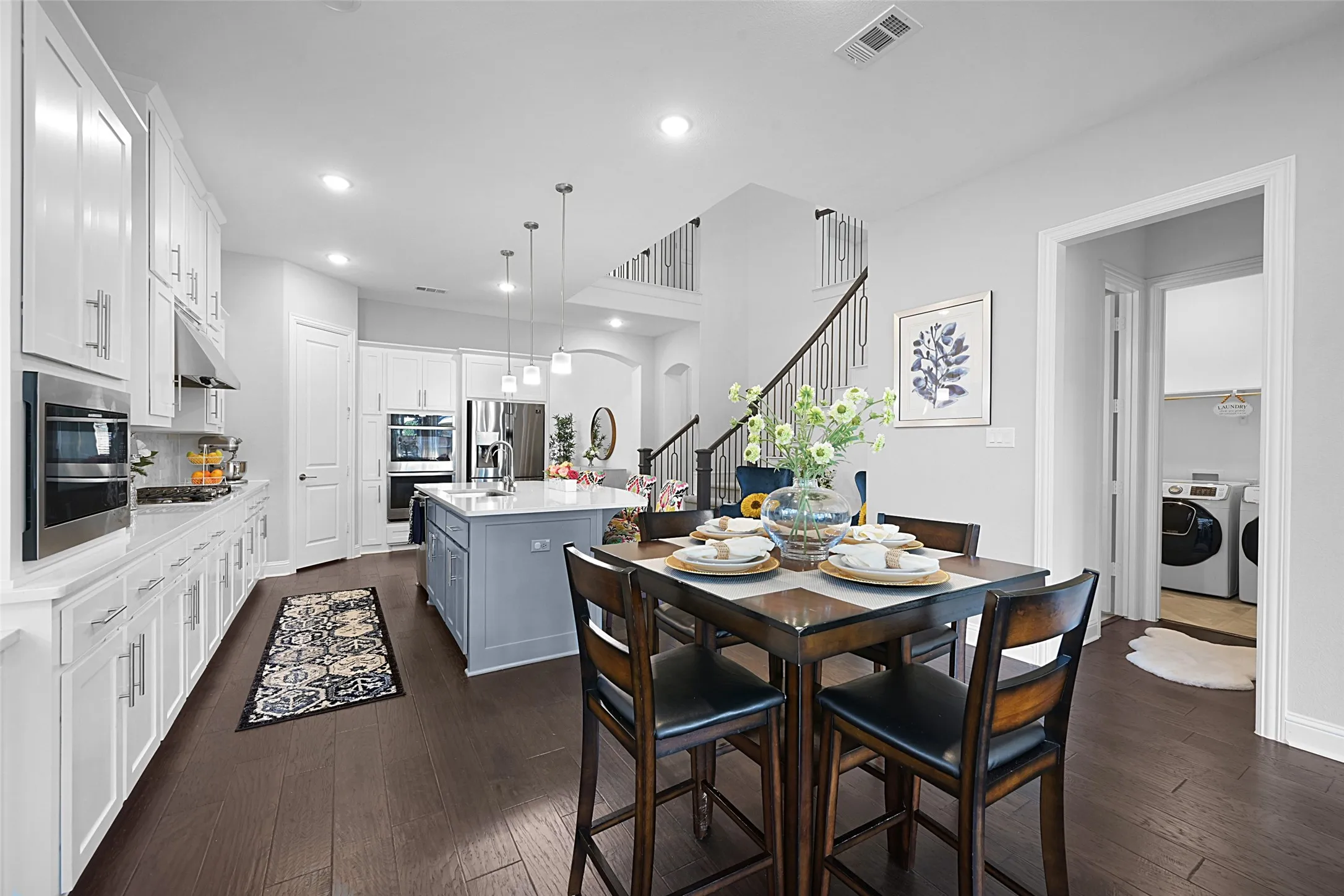 Expansive kitchen and dining area featuring dark wood-finish flooring