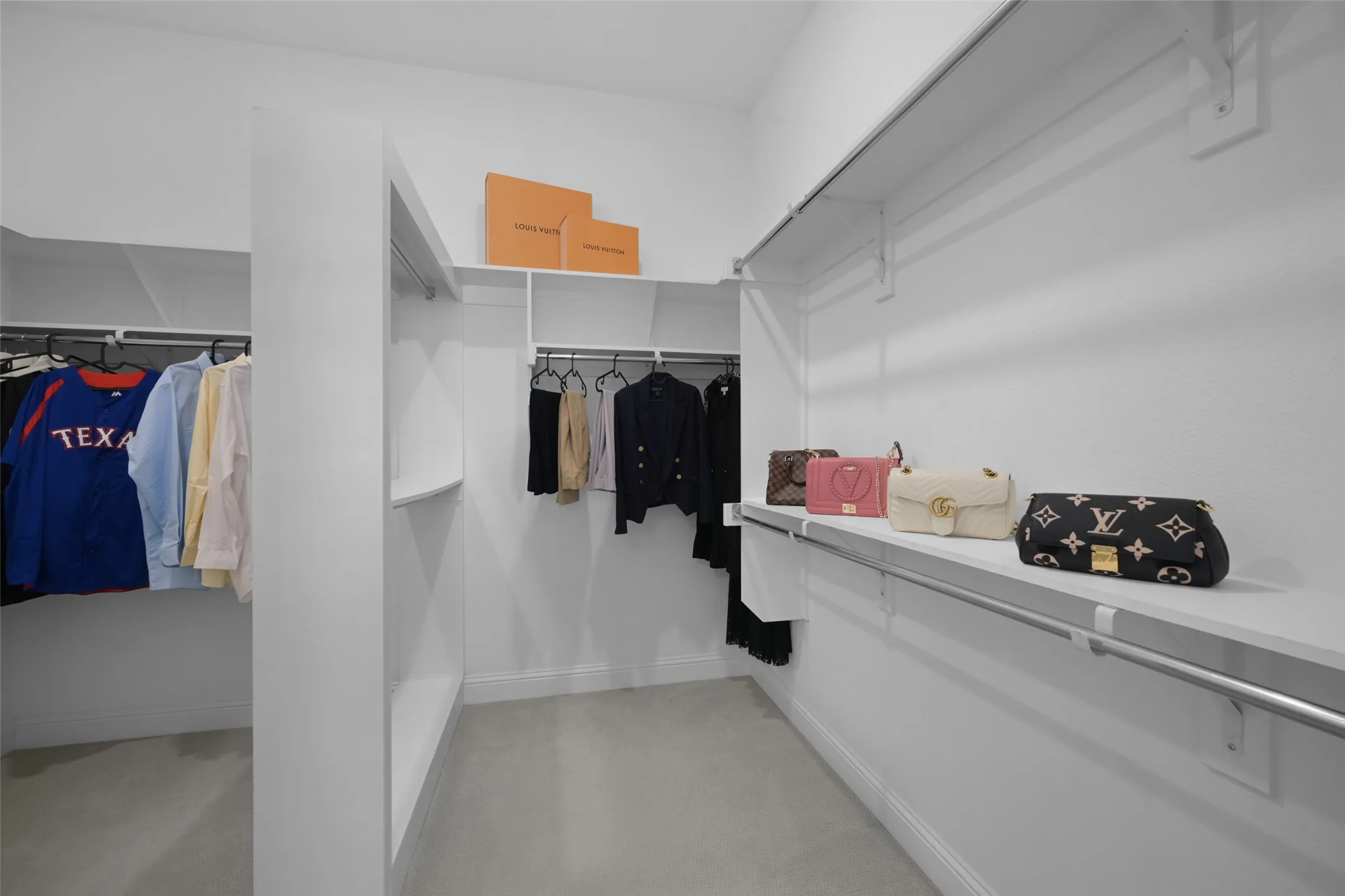 Custom closet system featuring multiple hanging rods, integrated shelving, and white finishes