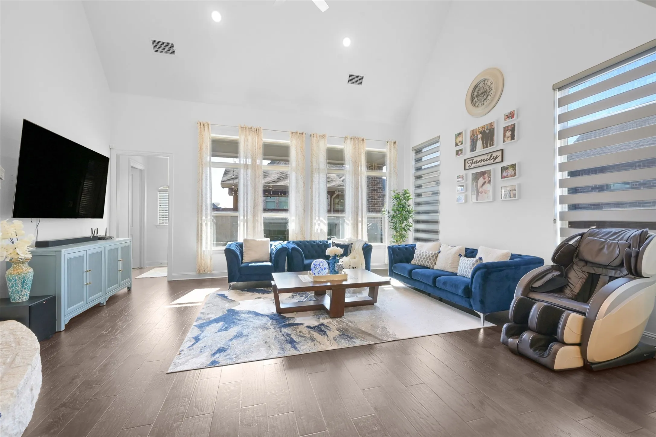 Spacious interior featuring a vaulted ceiling, wood-finish flooring, and ample natural light from multiple windows