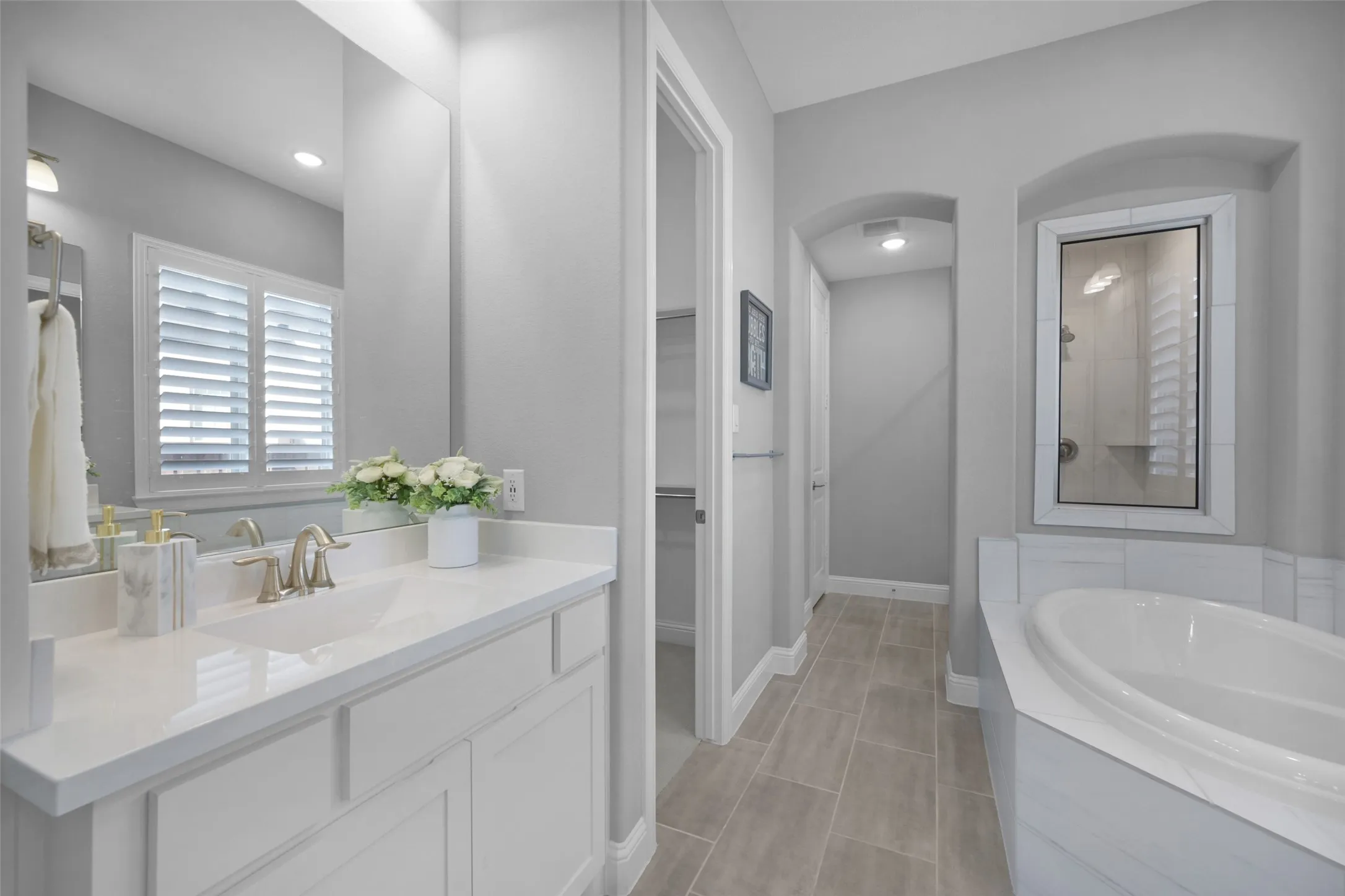 Bathroom featuring a white vanity with an integrated sink, brushed nickel faucet, and a large mirror