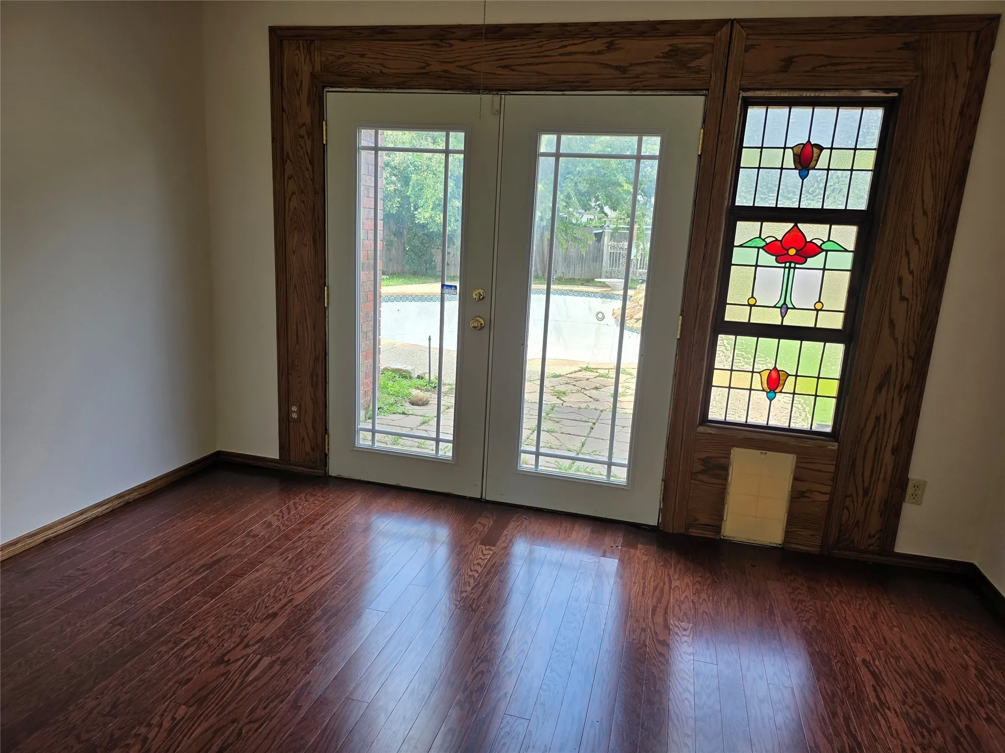 French doors with divided lites open to a patio and pool area