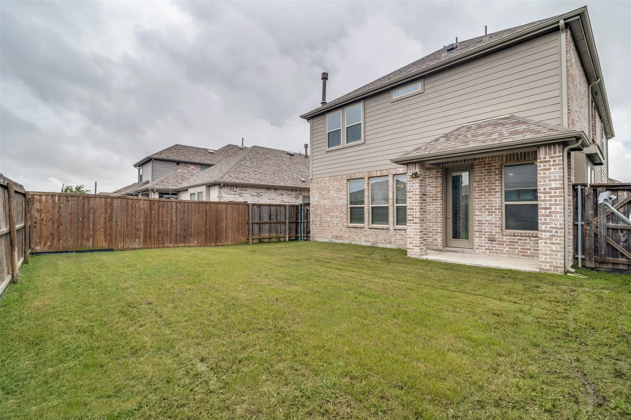 Expansive grassy yard with a wooden privacy fence