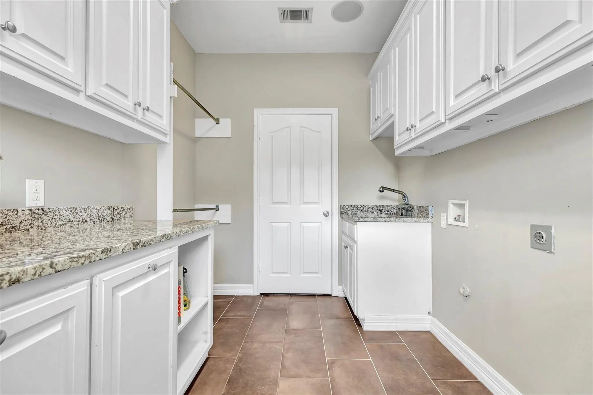 Love this laundry room with all the extra cabinetry, countertop, and sink.
