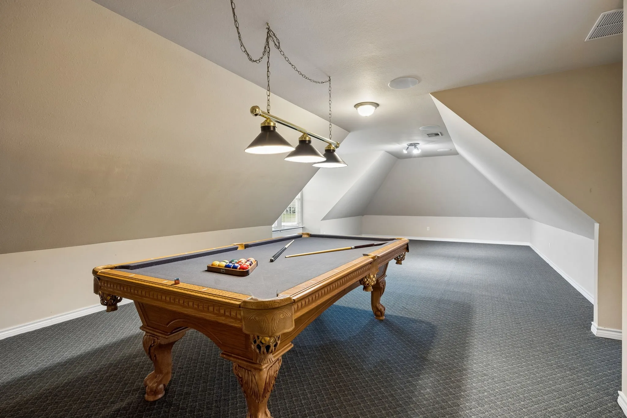 At the end of the hall, over the garage is a spacous rec type space. Pool table fits perfectly and will convey. There is still plenty of room for a big screen. The ultimately game watching fun zone.