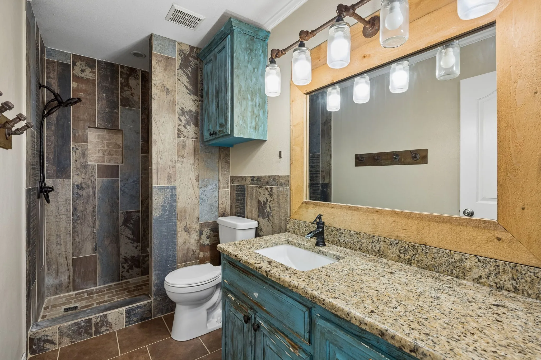 This bathroom will undergo cosmetic renovation with a neutral palate, new shower tile, vanity, mirror, lighting and paint.