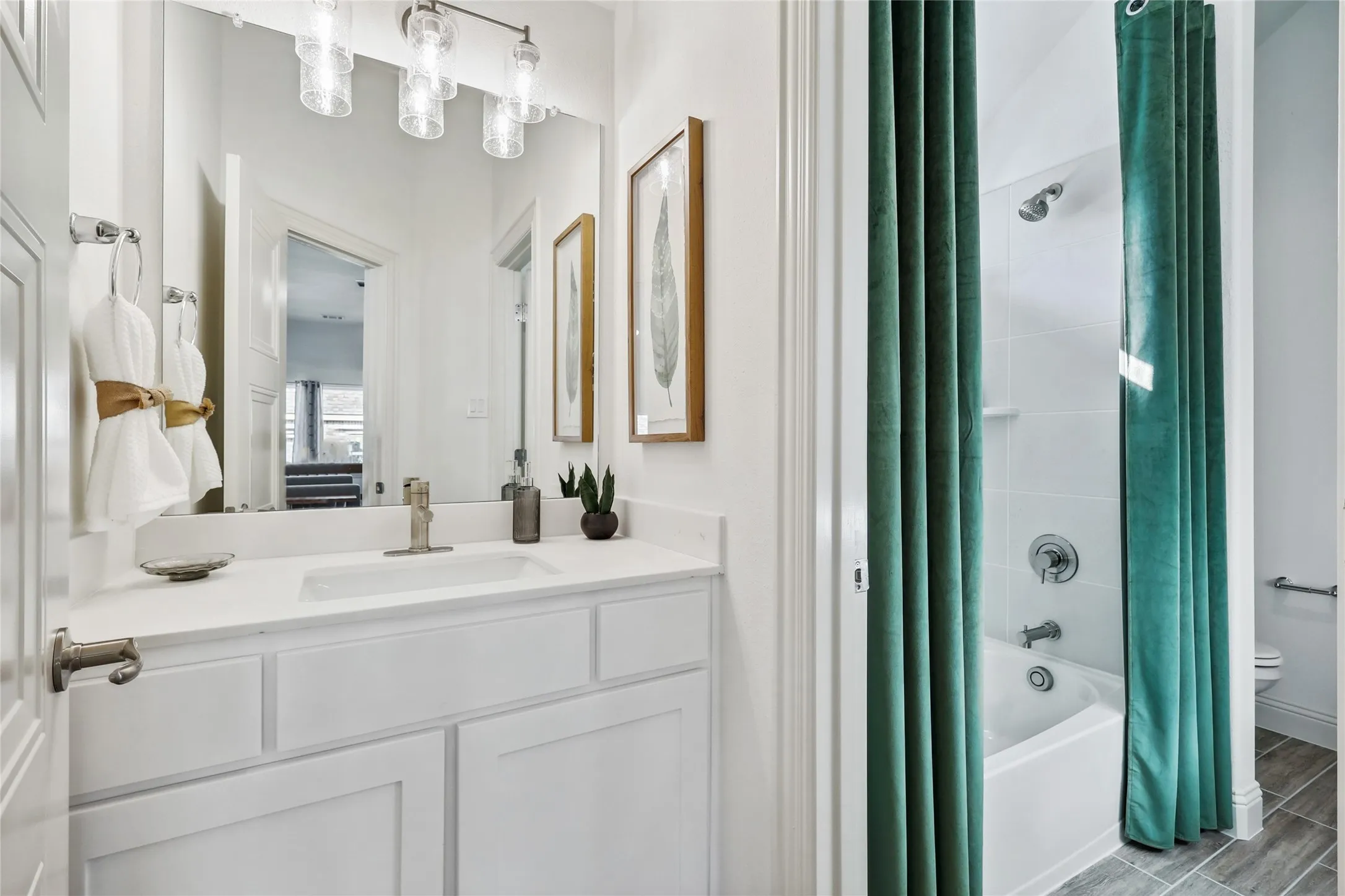 Bathroom featuring a white vanity with an integrated sink, brushed nickel faucet, and overhead linear vanity light