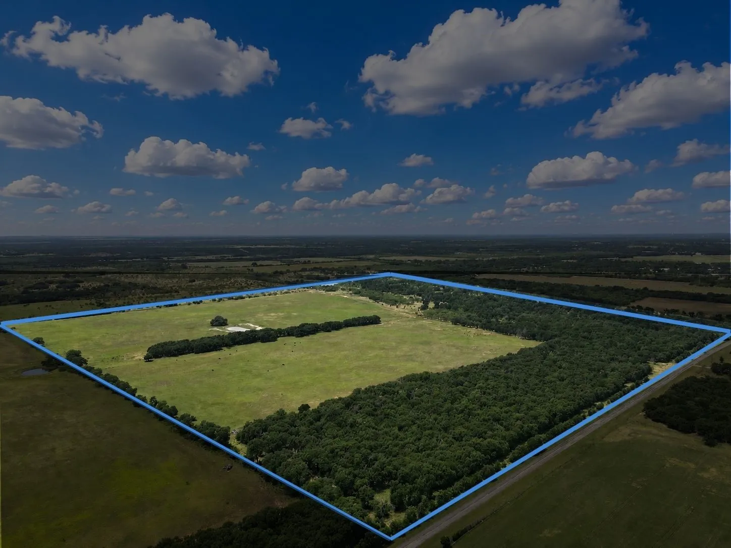 Expansive land parcel featuring a mix of open pastures and mature tree lines