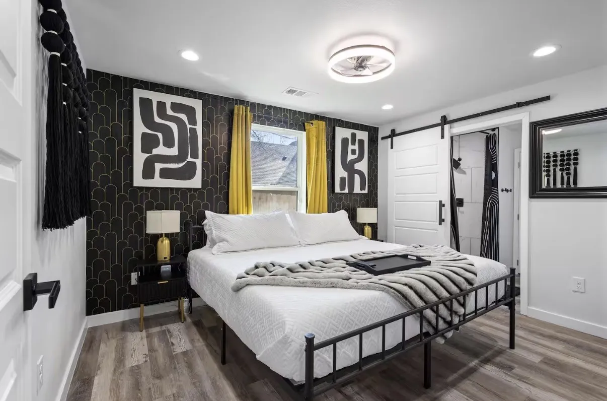 Bedroom featuring a striking accent wall with black and gold geometric wallpaper, wood-finish flooring, recessed lighting, and a modern ceiling fan