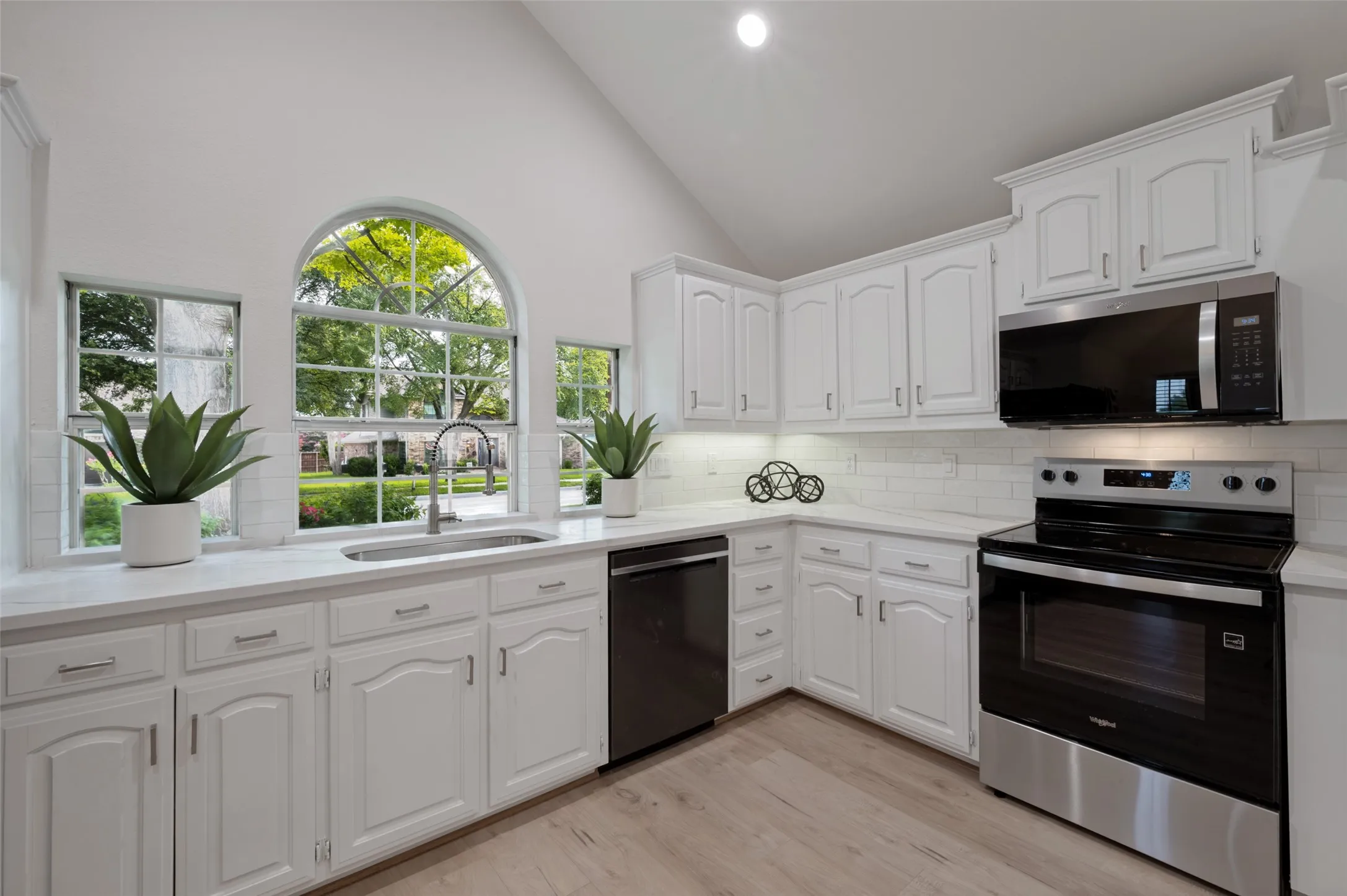 Kitchen featuring white cabinetry, white countertops, stainless steel appliances, and wood-finish flooring