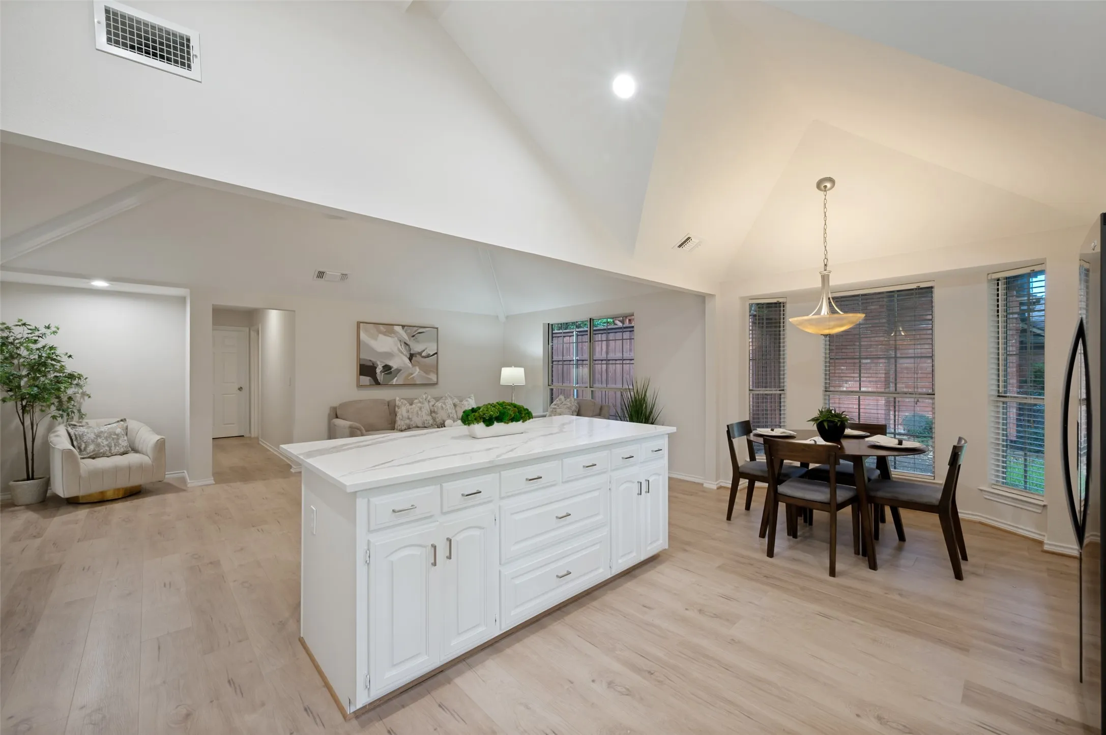Open-concept living space featuring vaulted ceilings and wood-finish flooring