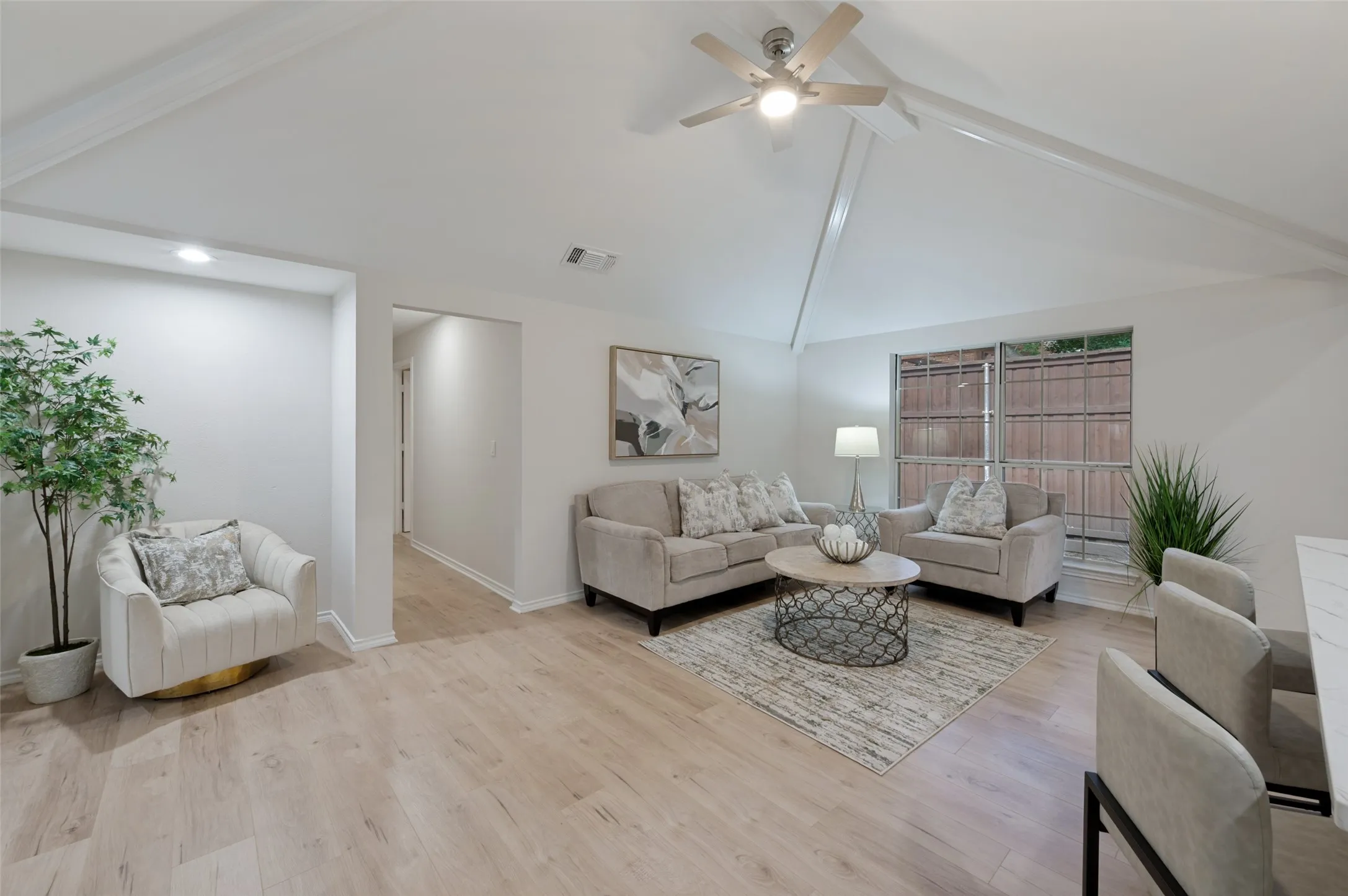 Living area featuring vaulted ceilings, wood-finish flooring, and a ceiling fan
