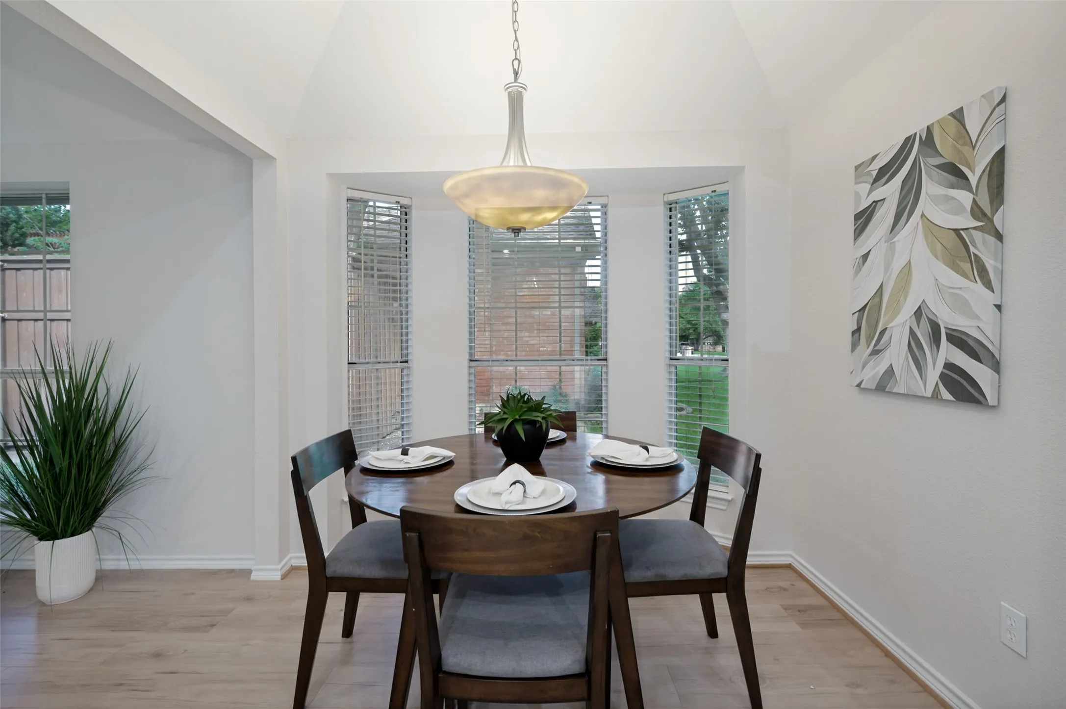 Dining area featuring a vaulted ceiling with a central pendant light fixture