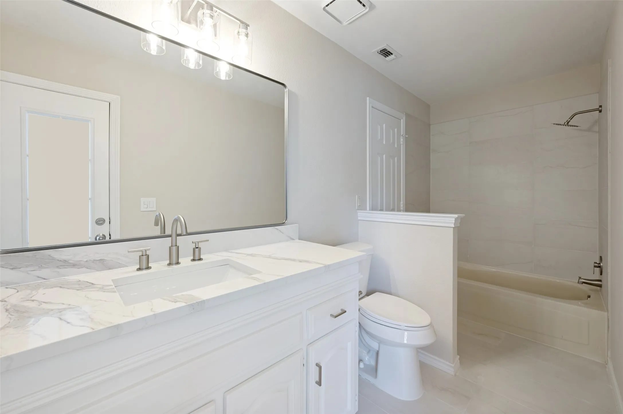 Bathroom featuring a white vanity with a marble-patterned countertop, an integrated rectangular sink, and brushed nickel fixtures