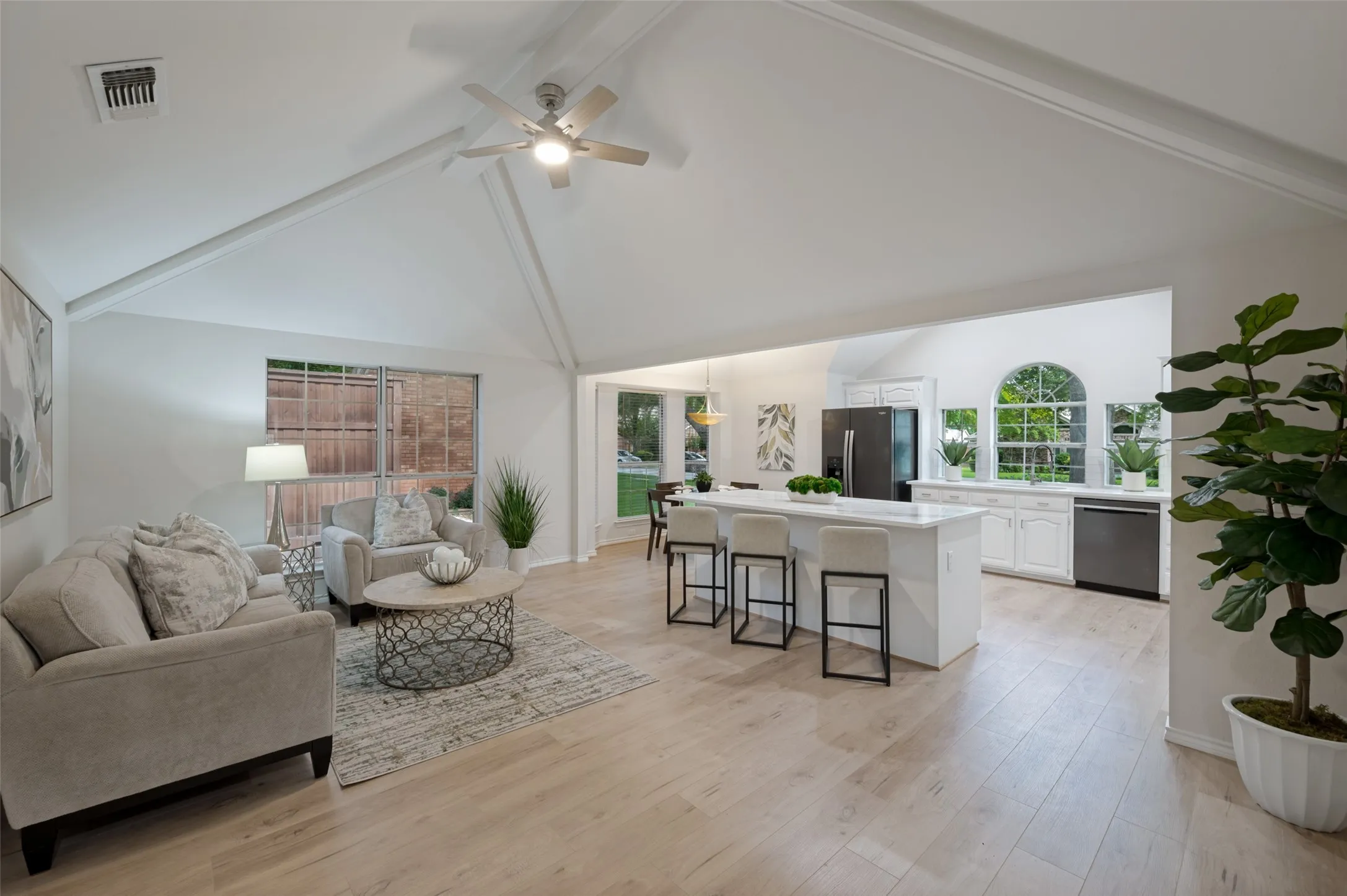Expansive living area with vaulted ceilings and wood-finish flooring
