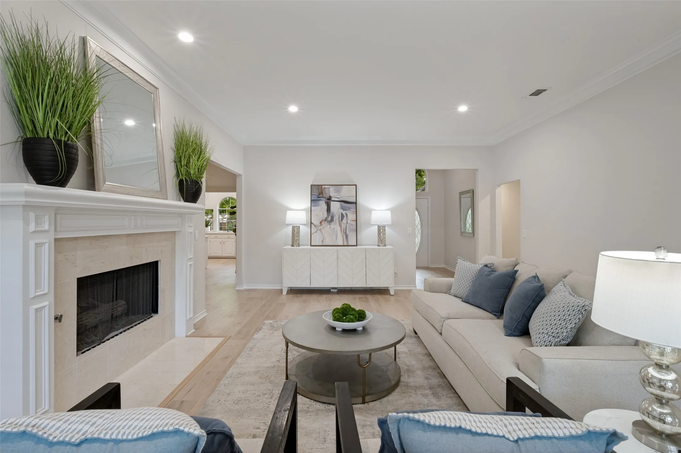 Spacious living area featuring light wood-finish flooring, recessed lighting, and crown molding