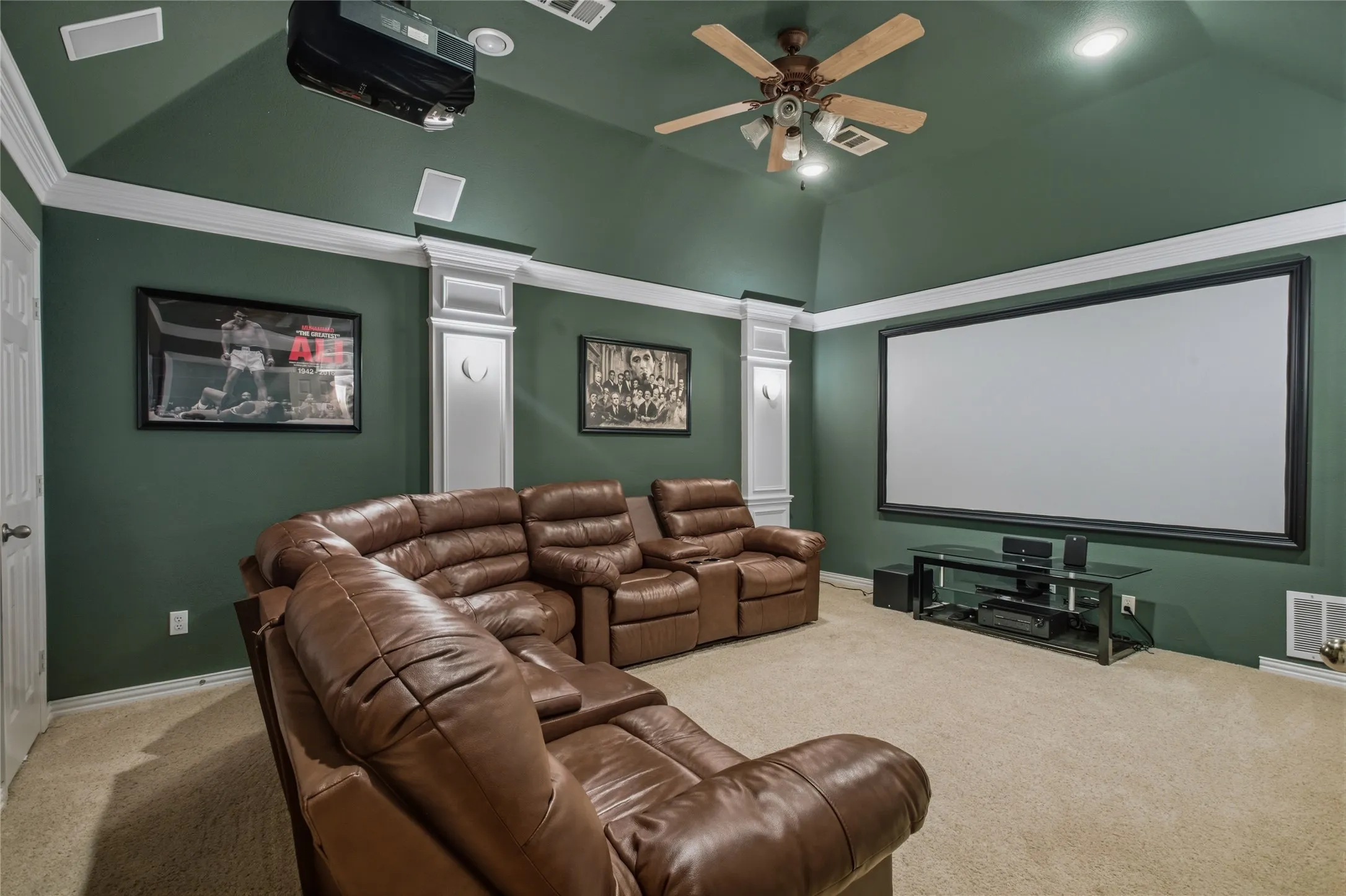 Media room featuring a large projection screen, ceiling-mounted Sony projector, recessed lighting.