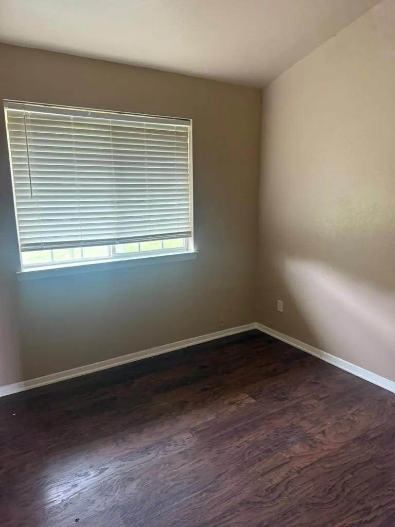 Neutral wall tones with a window featuring horizontal blinds