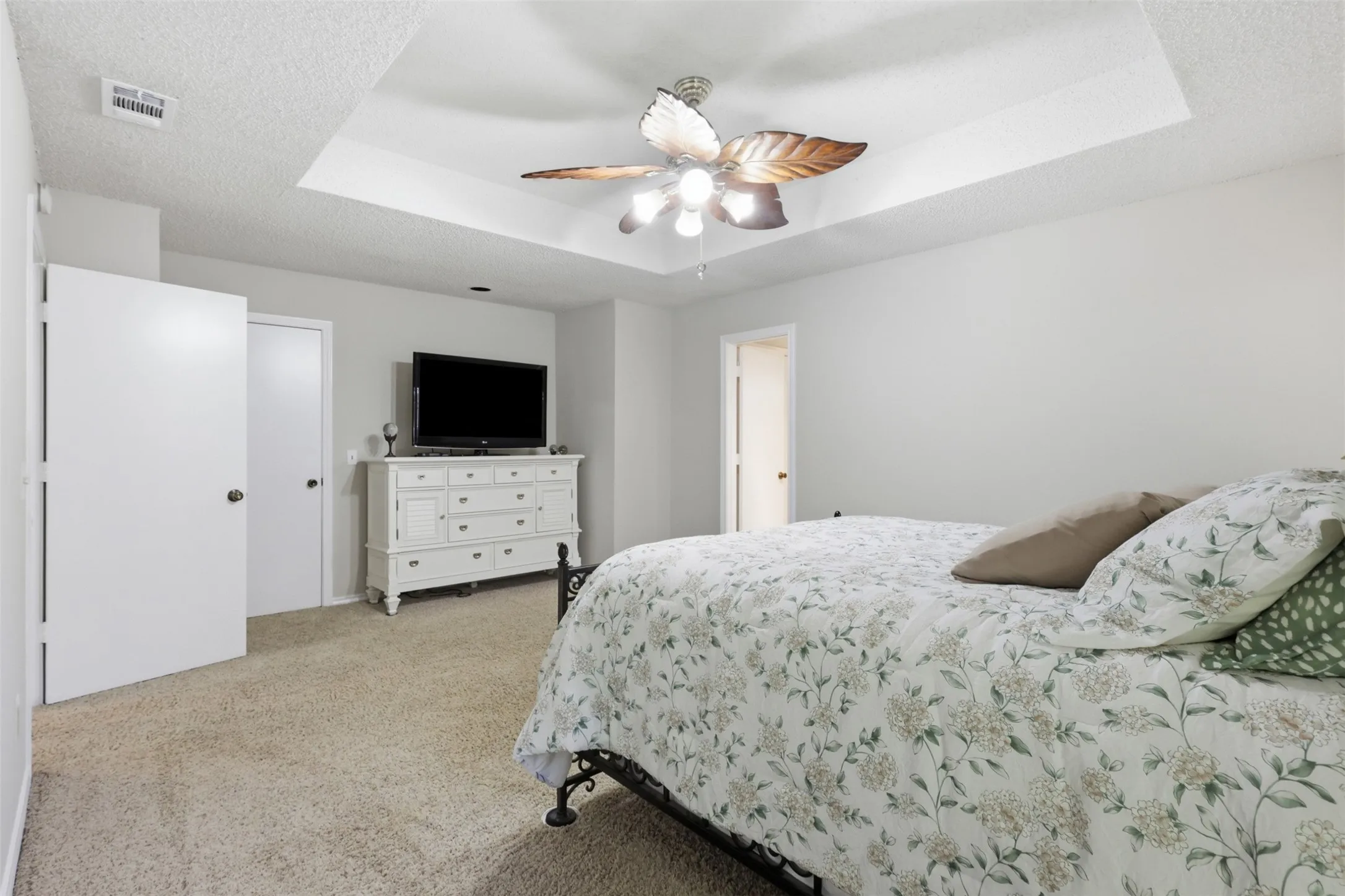 Recessed tray ceiling featuring a ceiling fan with integrated lighting