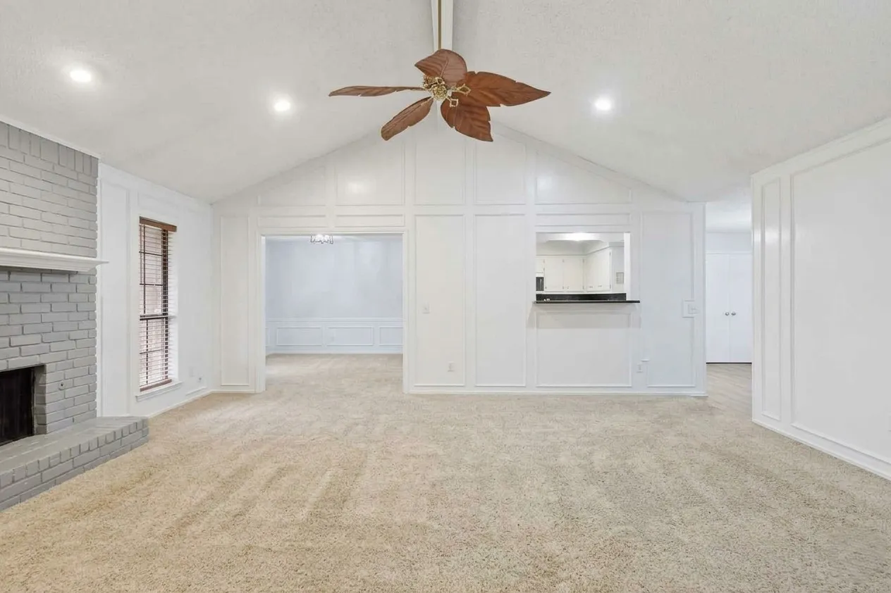 AI rendering of what the living room could look like painted white with a light grey brick around the fireplace.