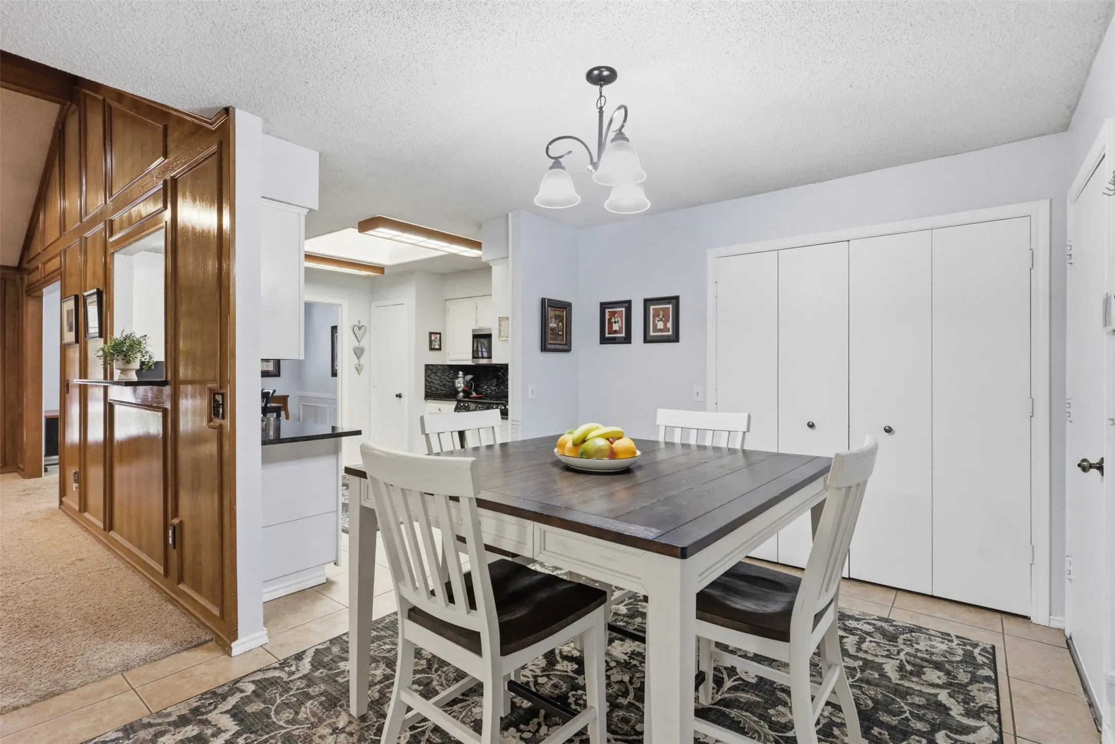Dining area featuring a neutral color palette, tile flooring, and a modern ceiling light fixture