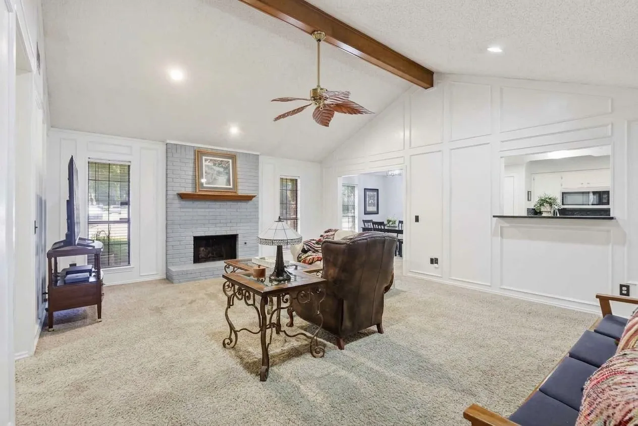 AI rendering of what the living room could look like painted white with a light grey brick around the fireplace.