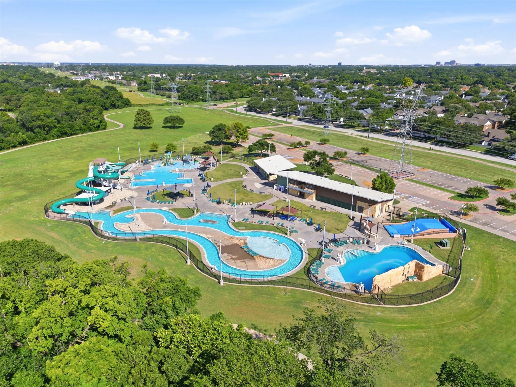 Expansive aquatic park featuring multiple pools, a winding lazy river, and water slides