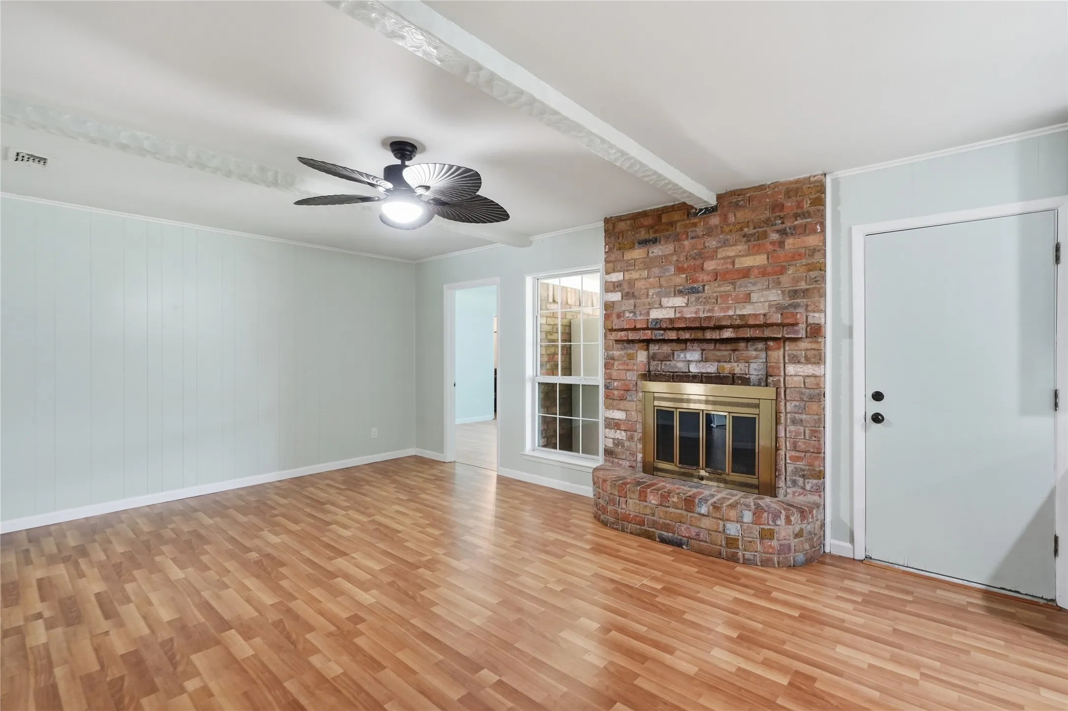 Brick fireplace with a brass-trimmed insert and hearth