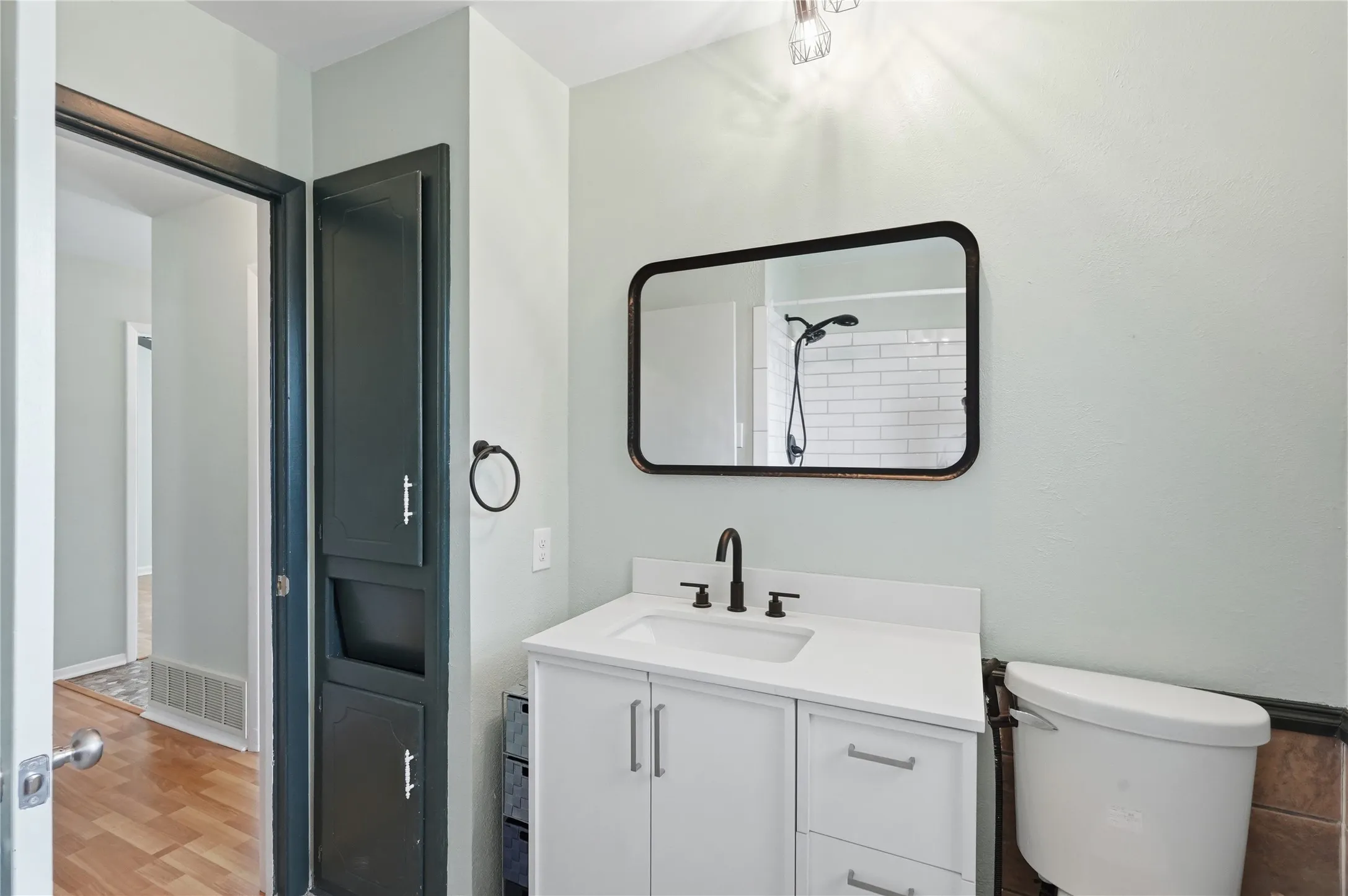 Bathroom vanity featuring a white countertop, undermount sink, and matte black faucet