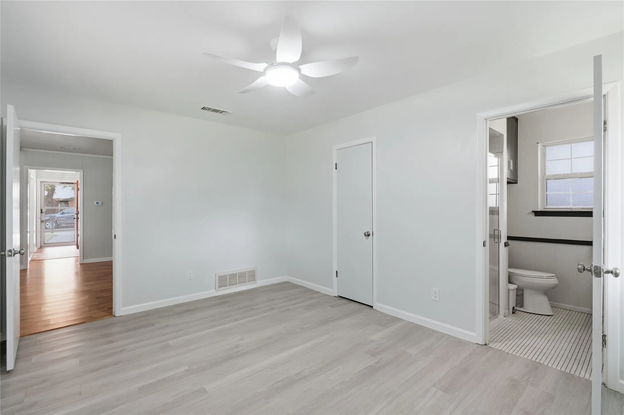 Interior room featuring light wood-finish flooring and a ceiling fan with integrated lighting