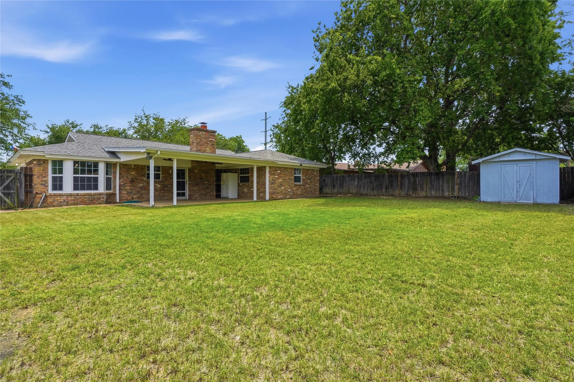 Expansive green lawn with a wood privacy fence