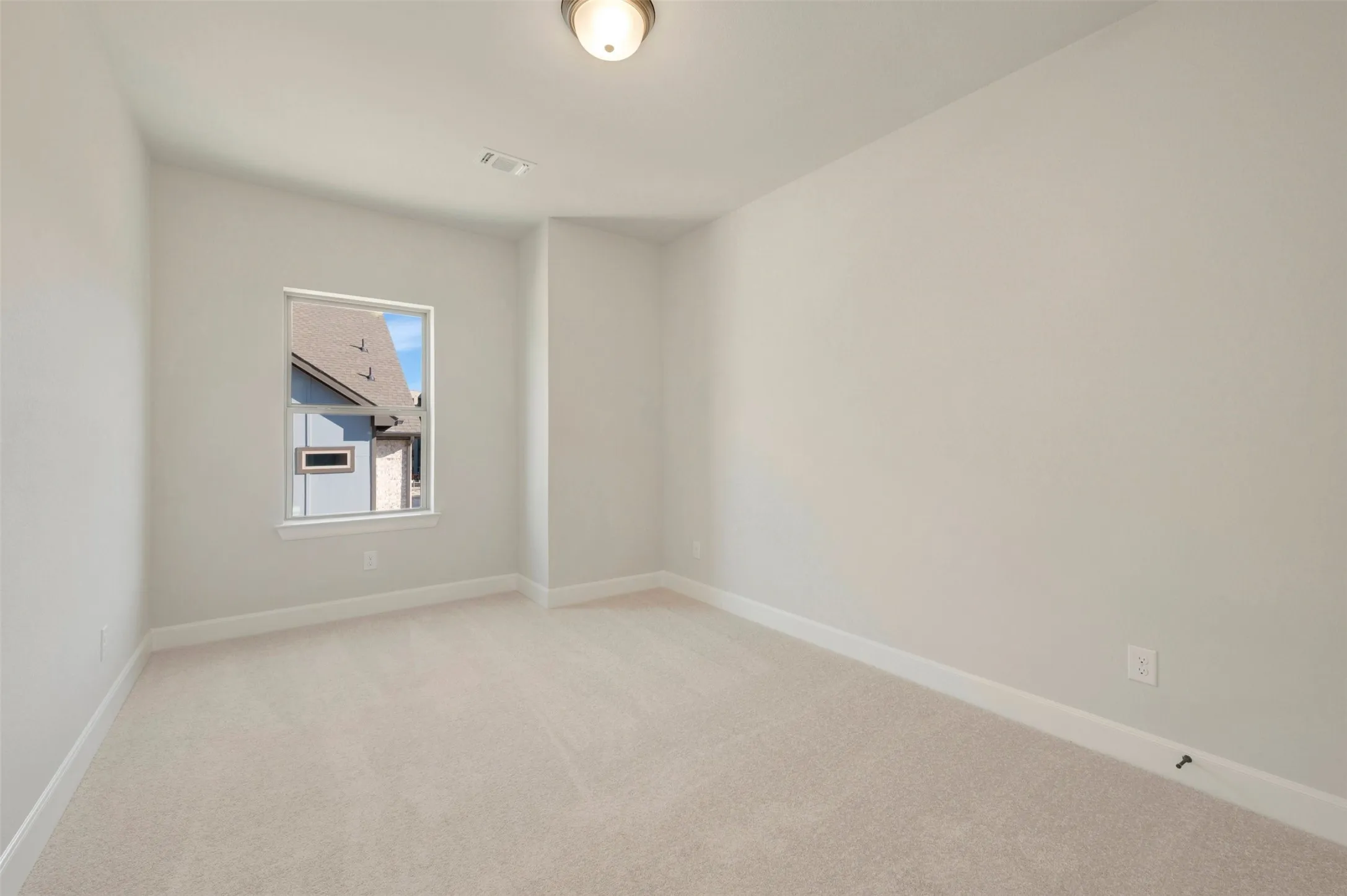 Neutral wall paint, plush carpet flooring, single window, and flush mount ceiling light