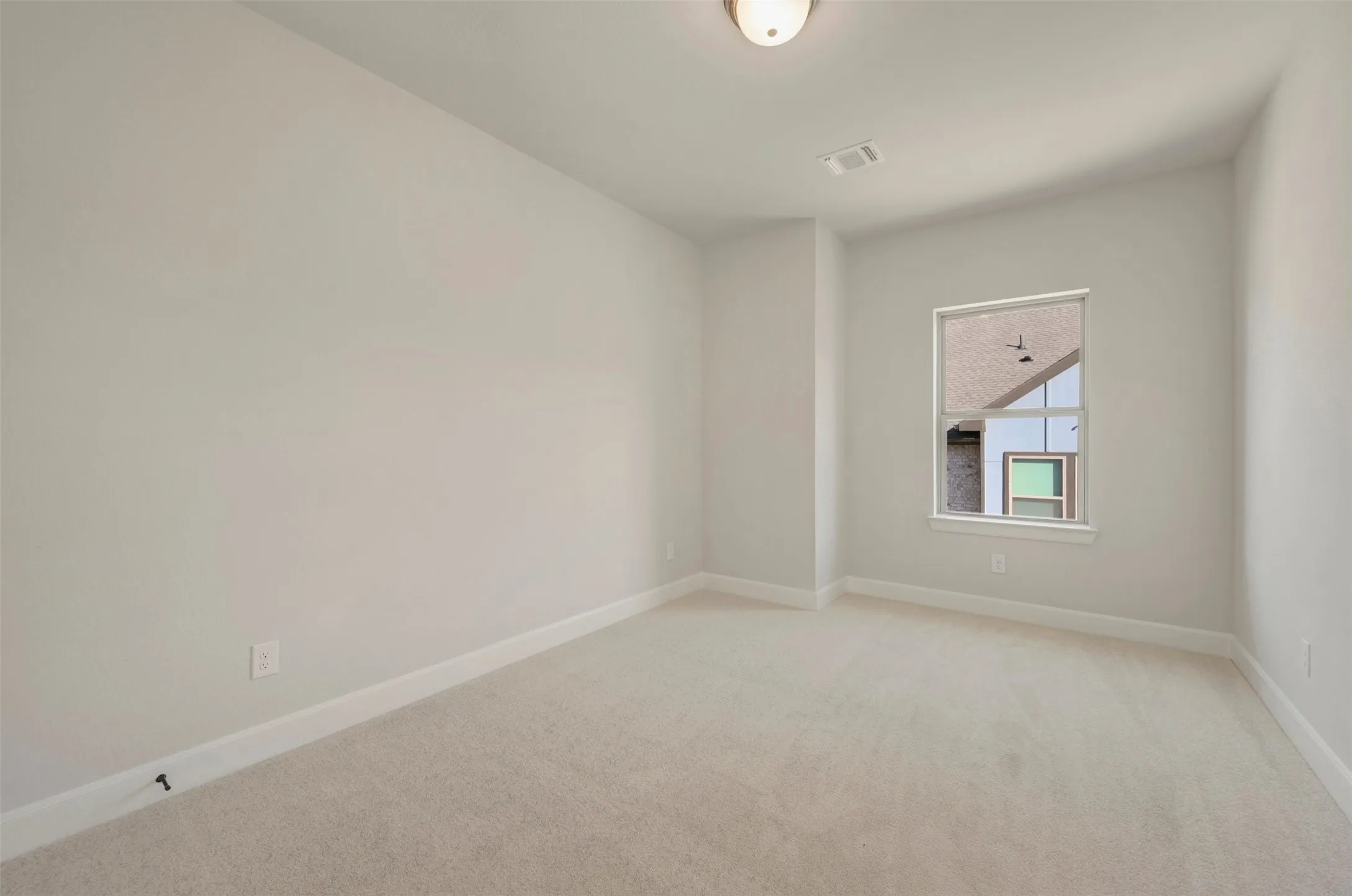 Plush carpeting, recessed window, ceiling-mounted light fixture, and neutral wall tones
