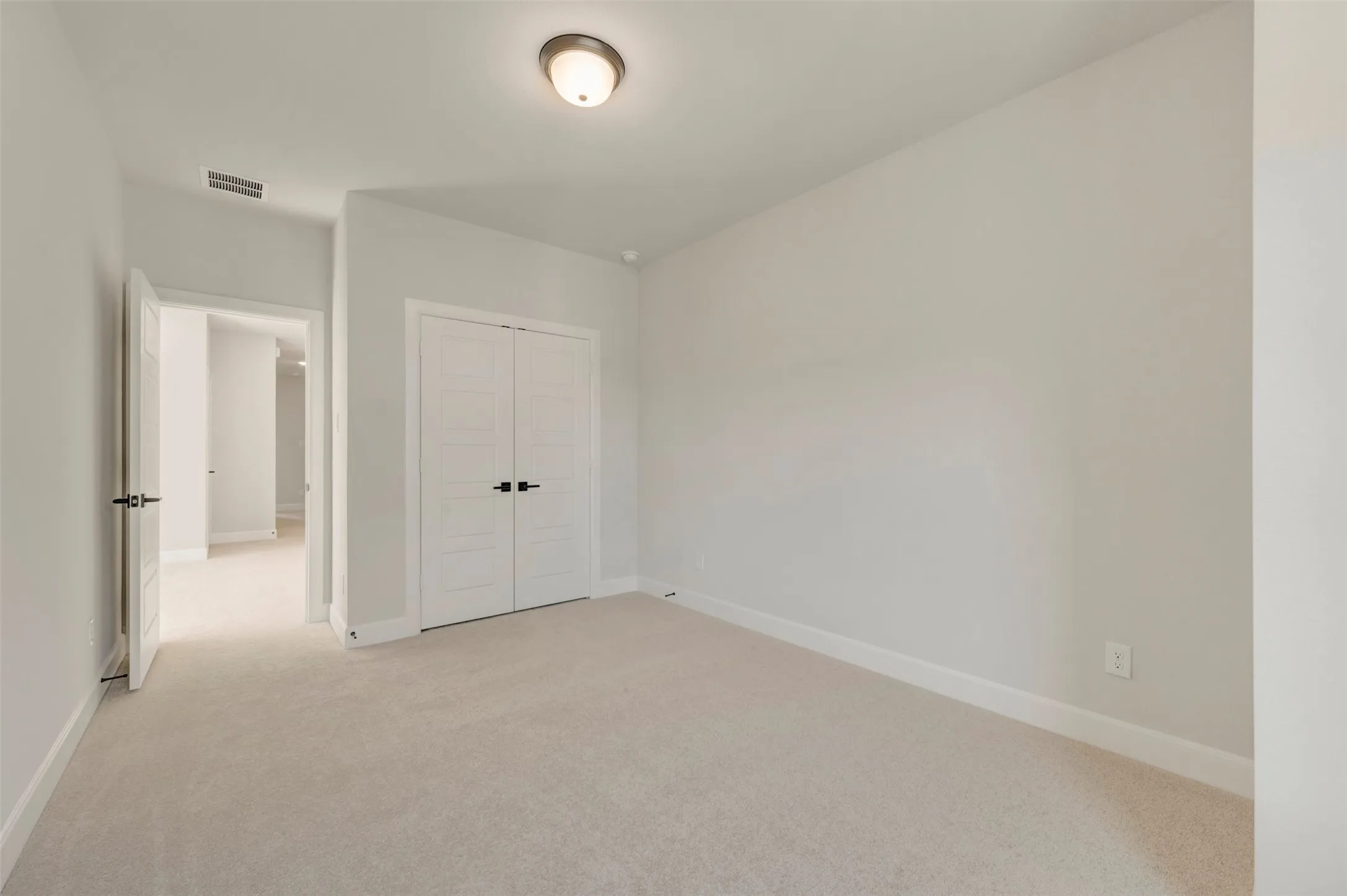 Neutral wall finishes, recessed lighting, double panel doors, and carpeting
