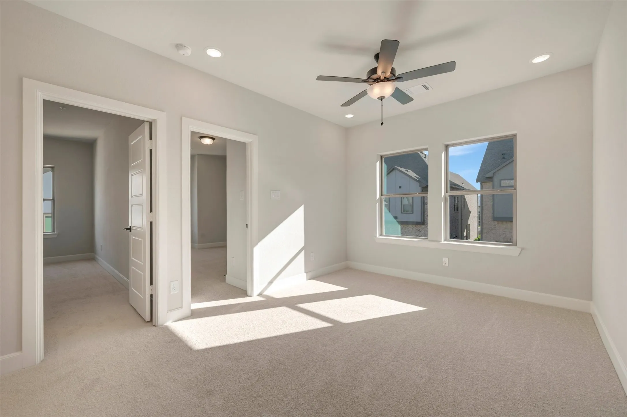 Recessed lighting, ceiling fan with integrated light, multiple windows, plush carpet flooring, and paneled interior doors