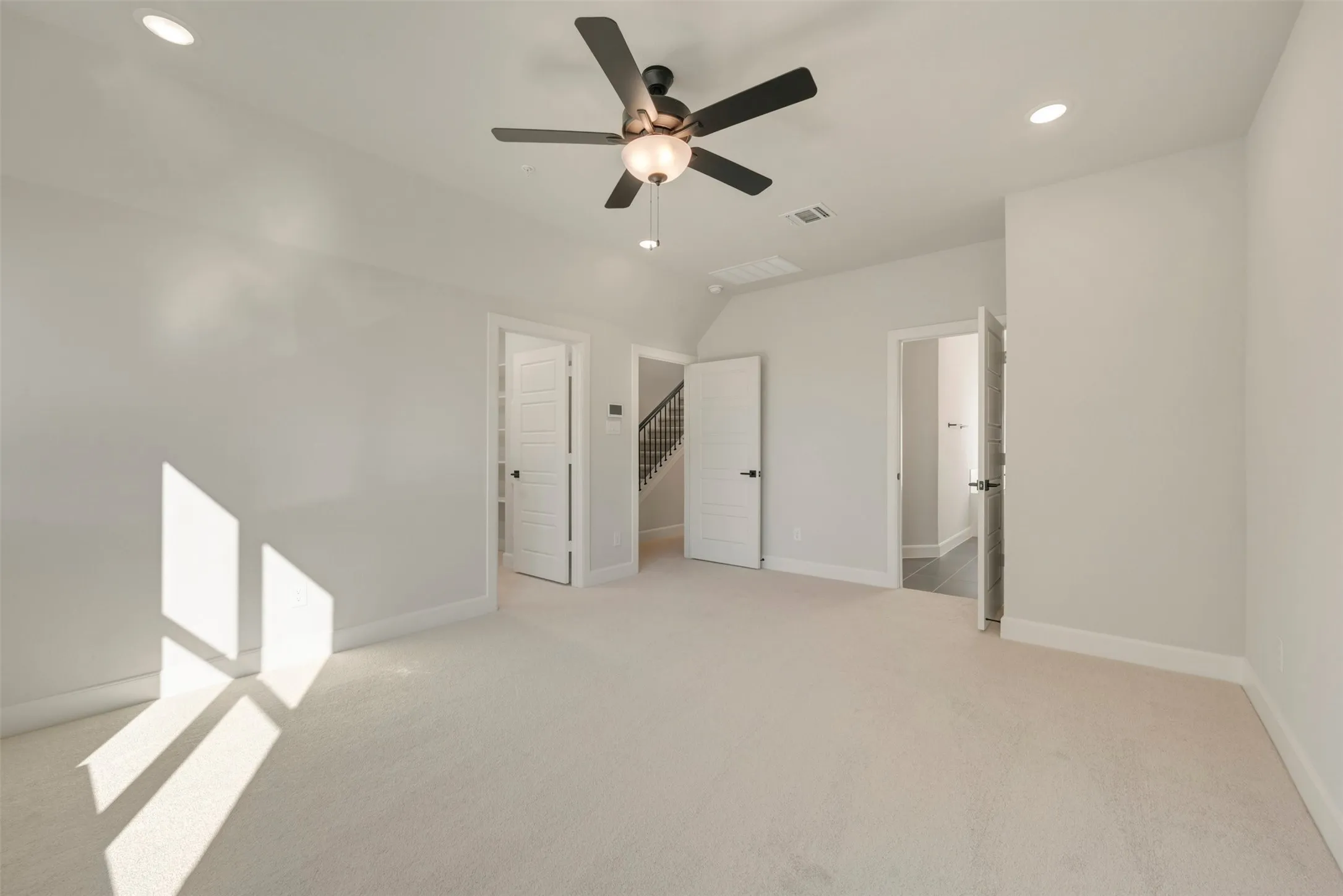 Carpeted flooring, recessed lighting, ceiling fan with light fixture, and multiple panel doors