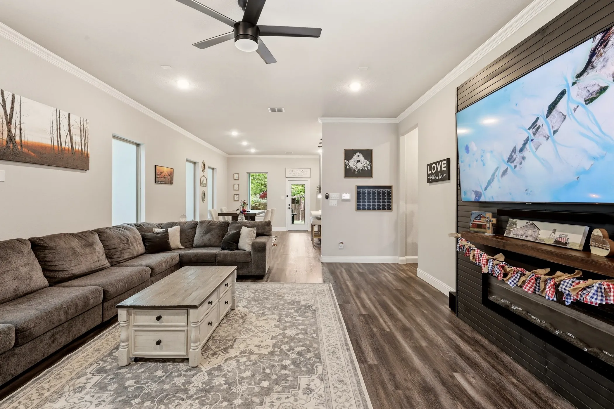 Spacious living area featuring wood-finish flooring, recessed lighting, and a ceiling fan