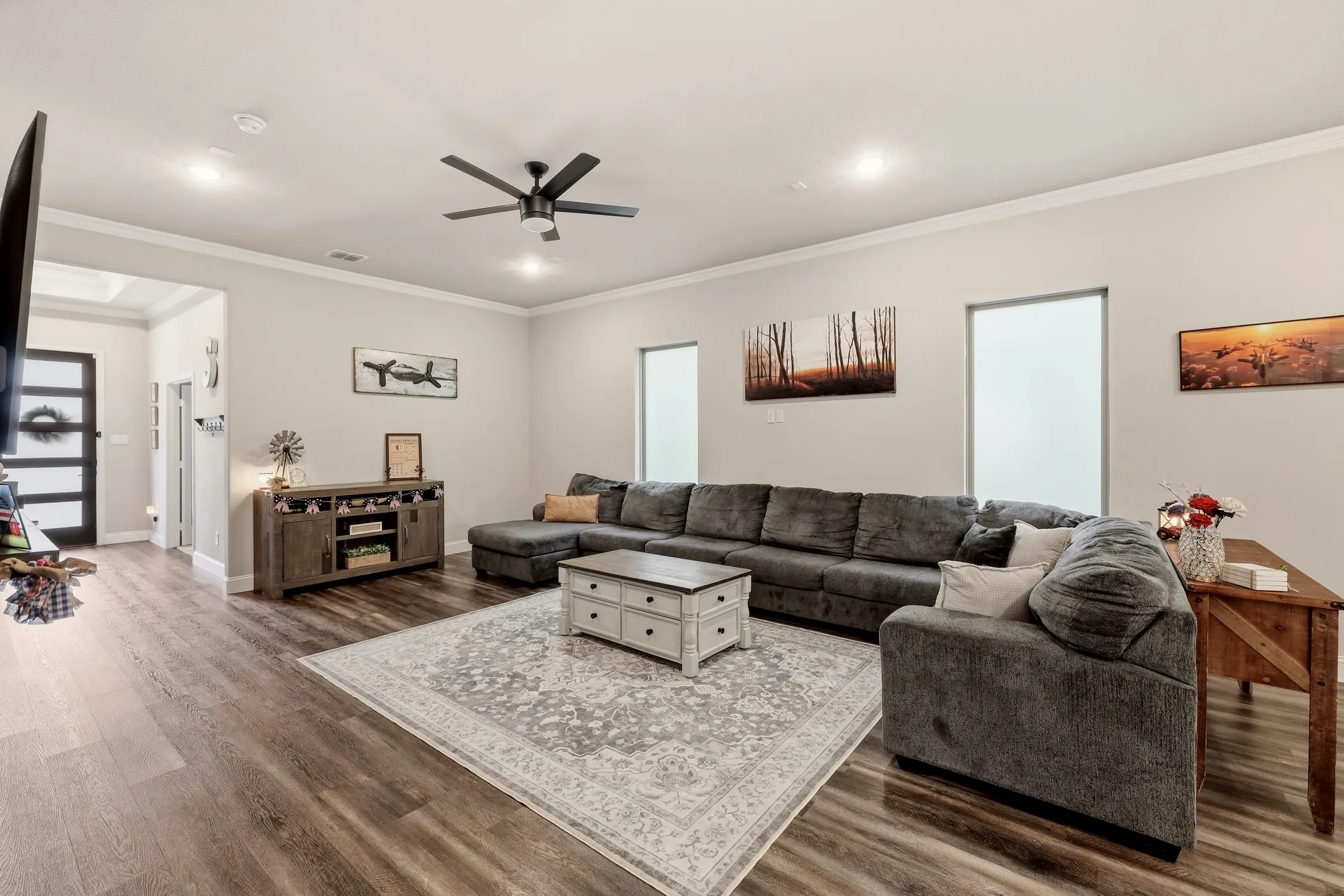 Spacious living area featuring wood-finish flooring, recessed lighting, and a ceiling fan