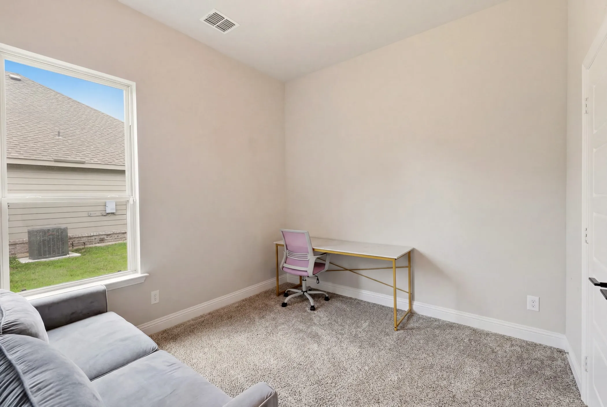 Carpeted interior room featuring neutral wall tones, baseboard molding, a rectangular window, and a white interior door with black hardware