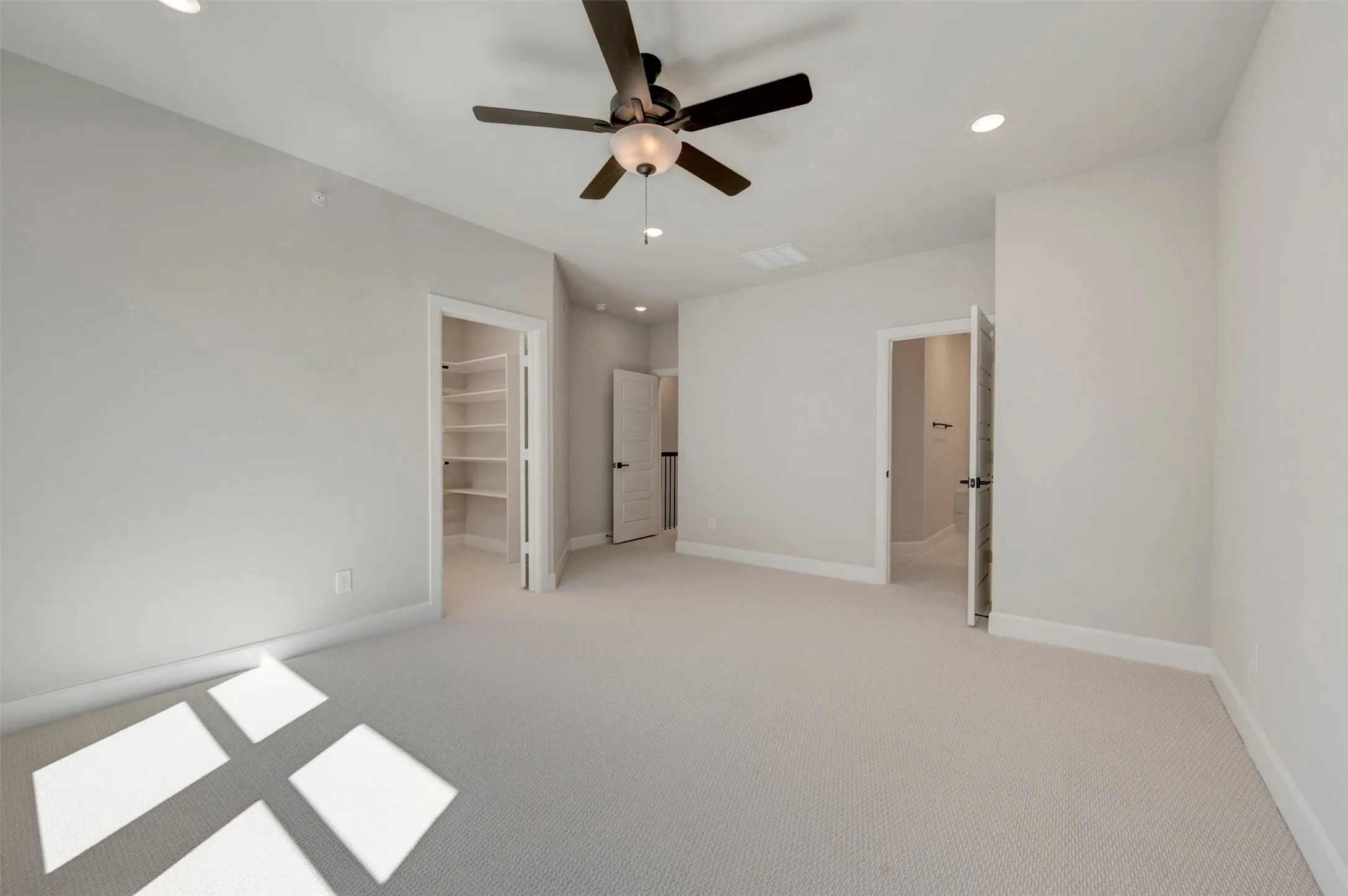 Carpeted room with recessed lighting, ceiling fan, and built-in closet shelving
