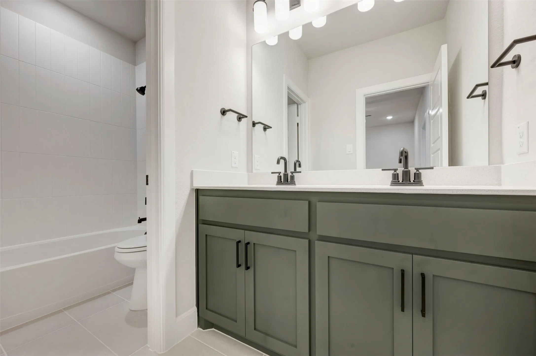 Dual vanity with quartz countertop, matte black fixtures, and cabinet storage