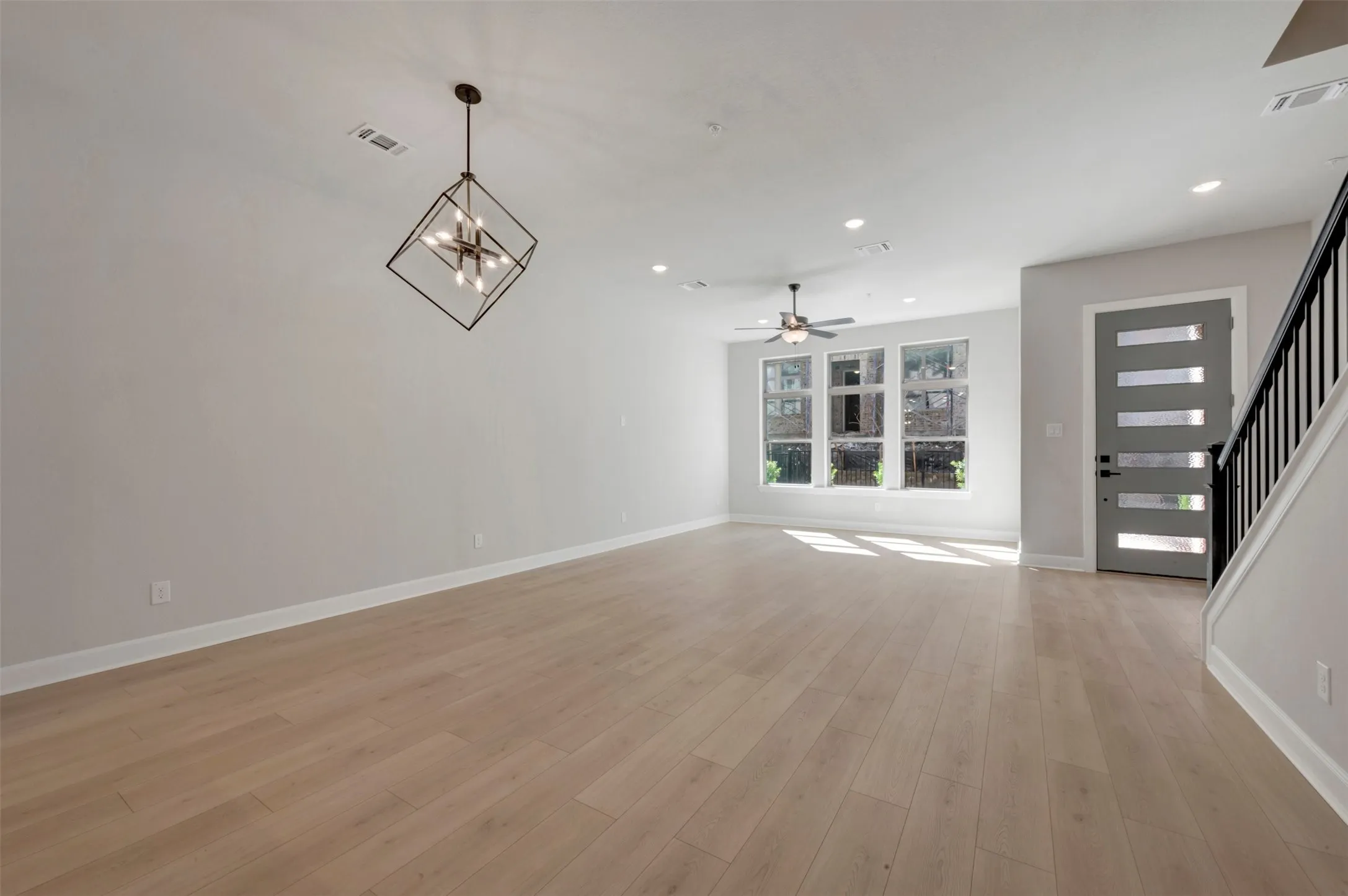 Wood-finish flooring, recessed lighting, and a contemporary light fixture