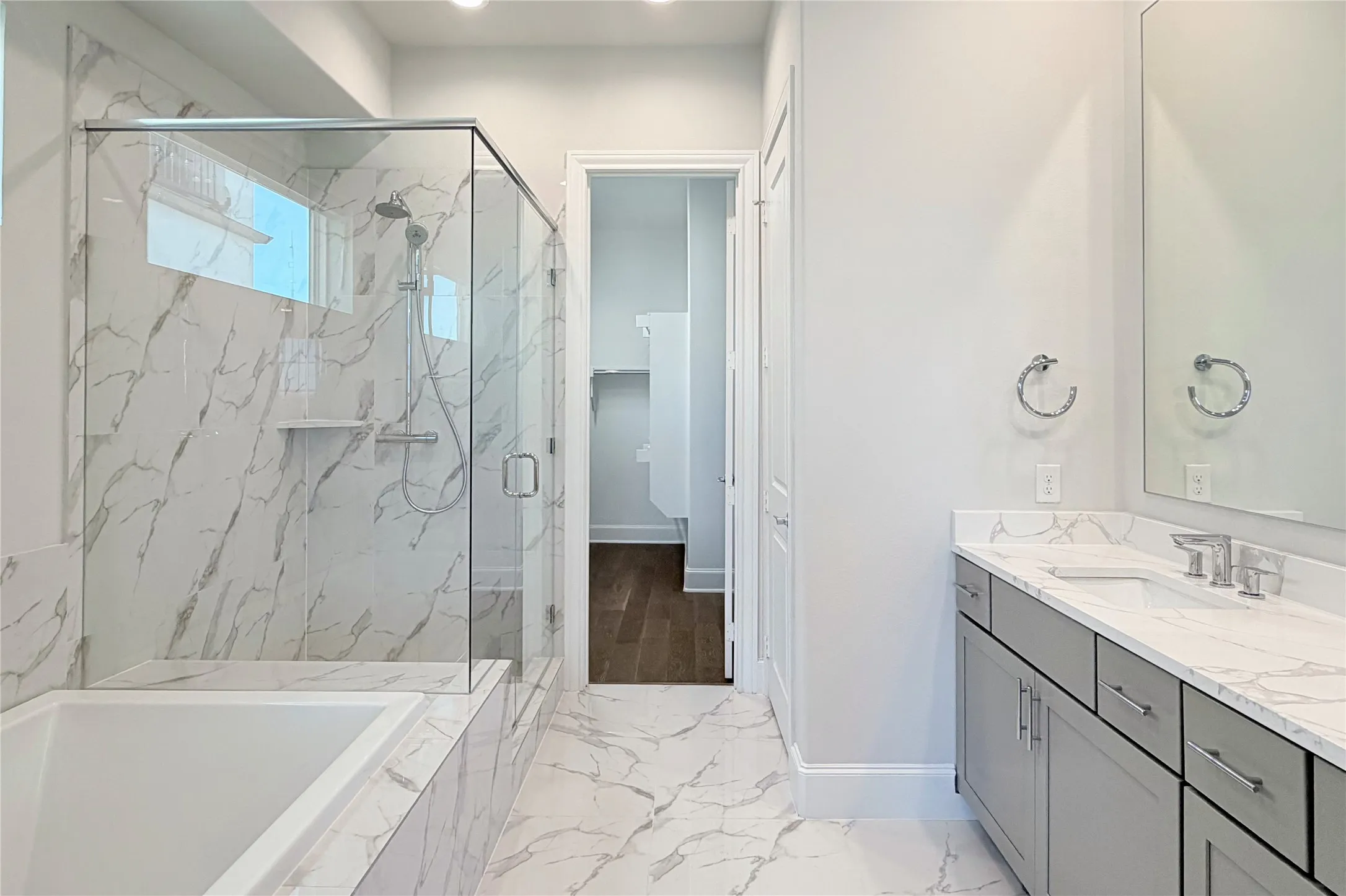 Progress photo of actual unit. Large drop-in tub with separate walk-in shower with semi-framless glass enclosure, dual vanity and spacious walk-in closet.