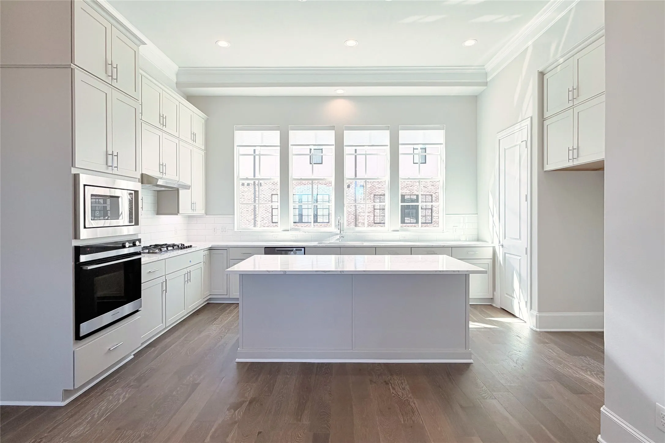 Progress photo of actual unit. Upgraded stacked cabinetry, warm neutral finishes, and abundant natrual light.